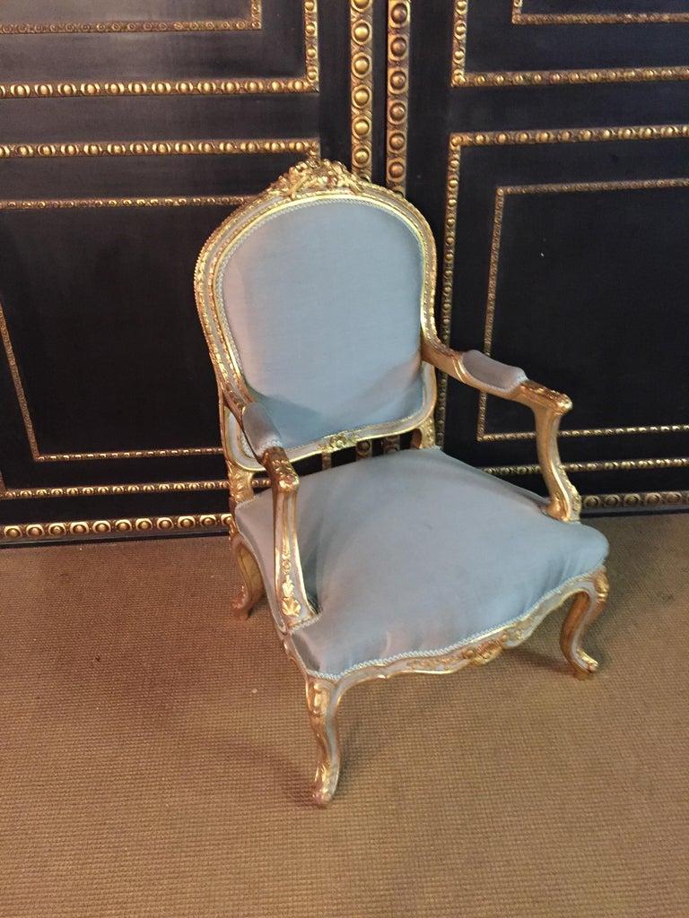 Solid beechwood, carved, colored and gilded. Semicircular rising backrest frame with rocaille crowning. Appropriately curved, carved frame. Slightly curved frame on curly legs. The seat and backrest are finished with a historic, Classic upholstery,