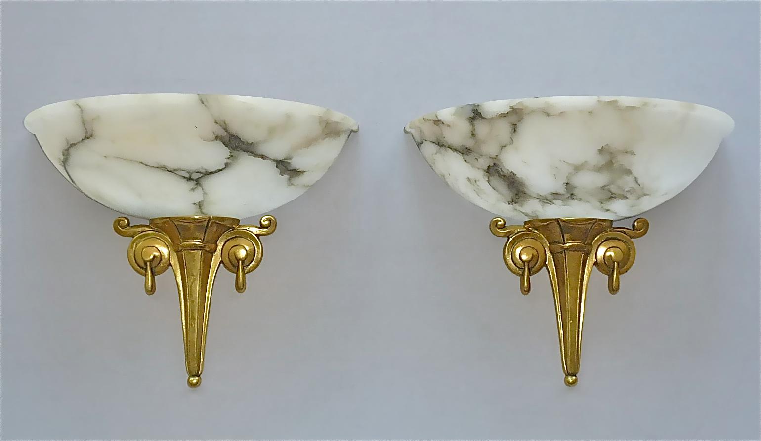 Rare pair French gilt bronze and unique carved creamy white beige or ivory color alabaster half bowl sconces with beautiful charcoal mineral veining in black and silver grey from the Art Deco period, France, circa 1920 to 1930. The amazing and high