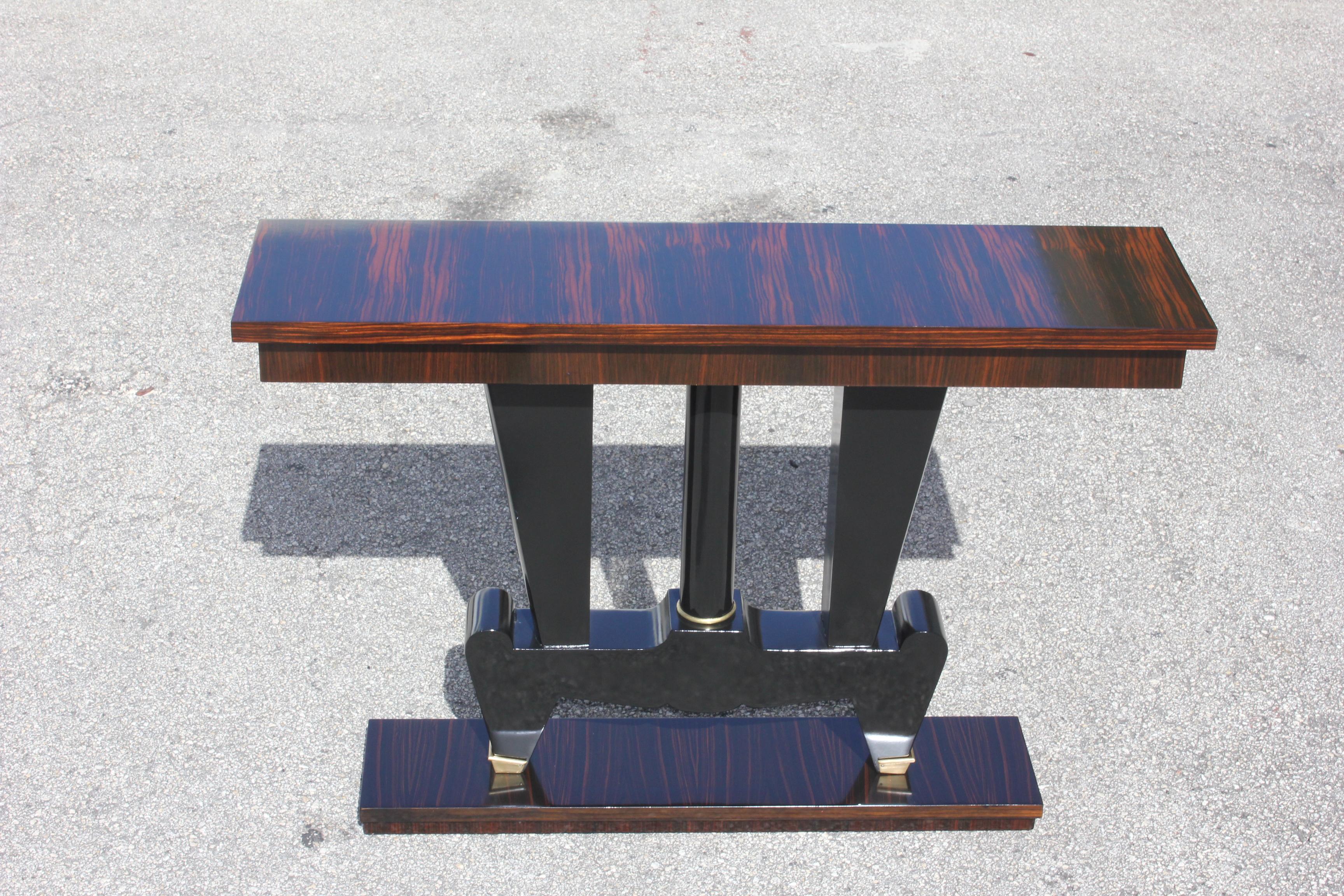 Unique French art deco exotic Macassar ebony console tables, circa 1940s. Beautiful Macassar ebony with black lacquer base, high gloss lacquer finish in both side, beautiful bronze hardware detail, that rest on makes it ideal for use as a bedside