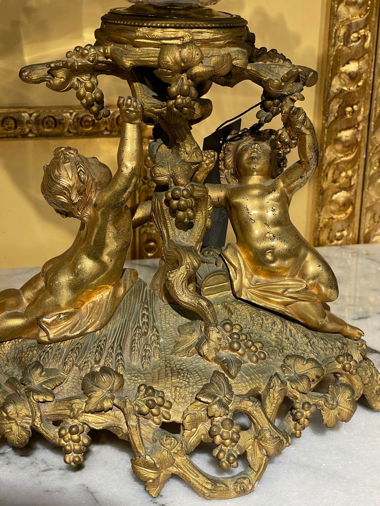 Unique French table top, fire-gilded bronze around 1860.

Fire-gilded bronze, base with two puttos holding the antique hand-cut round glass bowl. Extremely finely crafted centerpiece. Wonderful shape. Gilded bronze and finely chased.