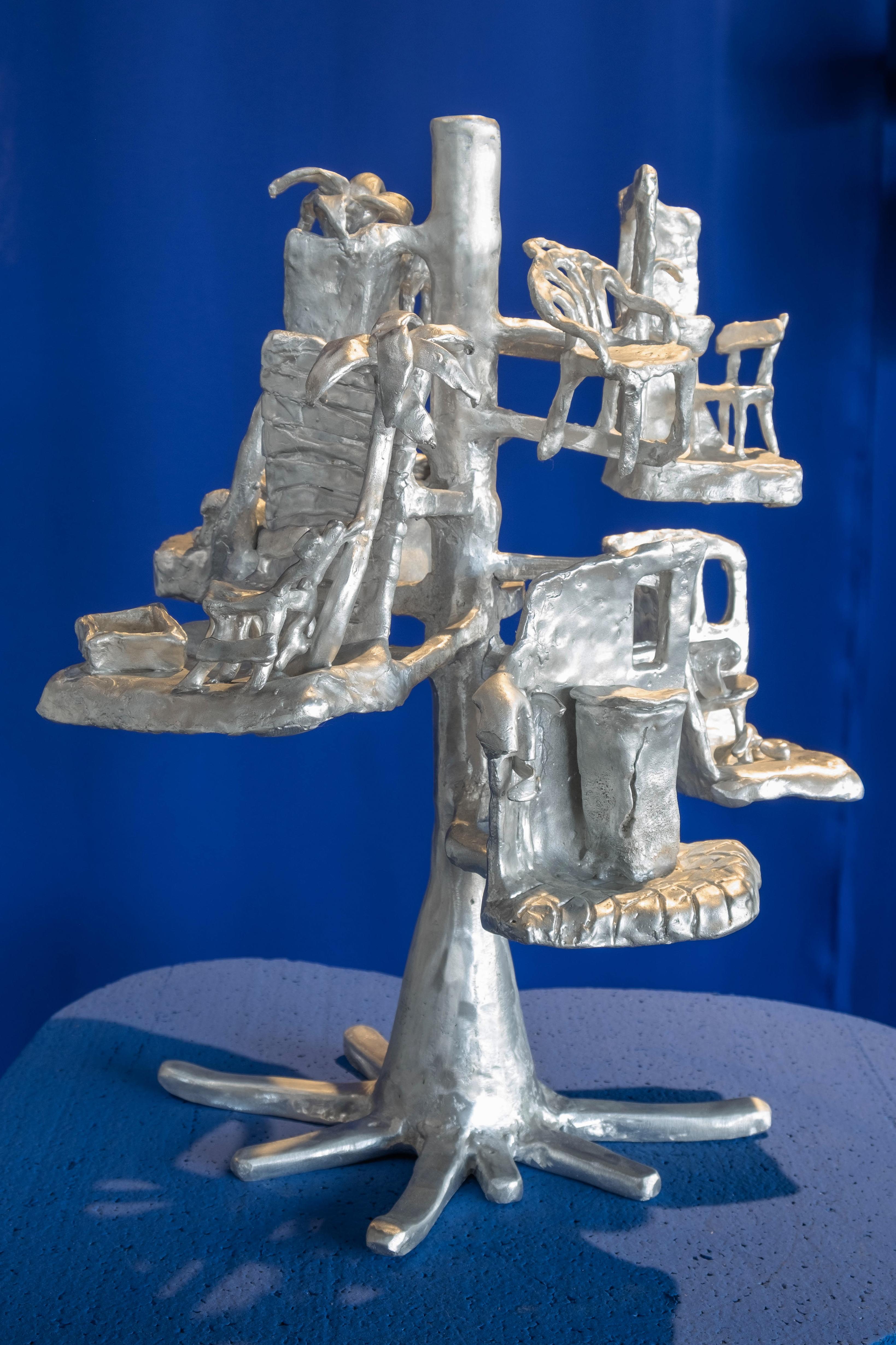 This functional standing sculpture is also used as candle holder. 
Unique signed piece that comes with a certificate of authenticity.

This aluminium cast was first modeled in bee wax. The tree and the channels are the technical parts required