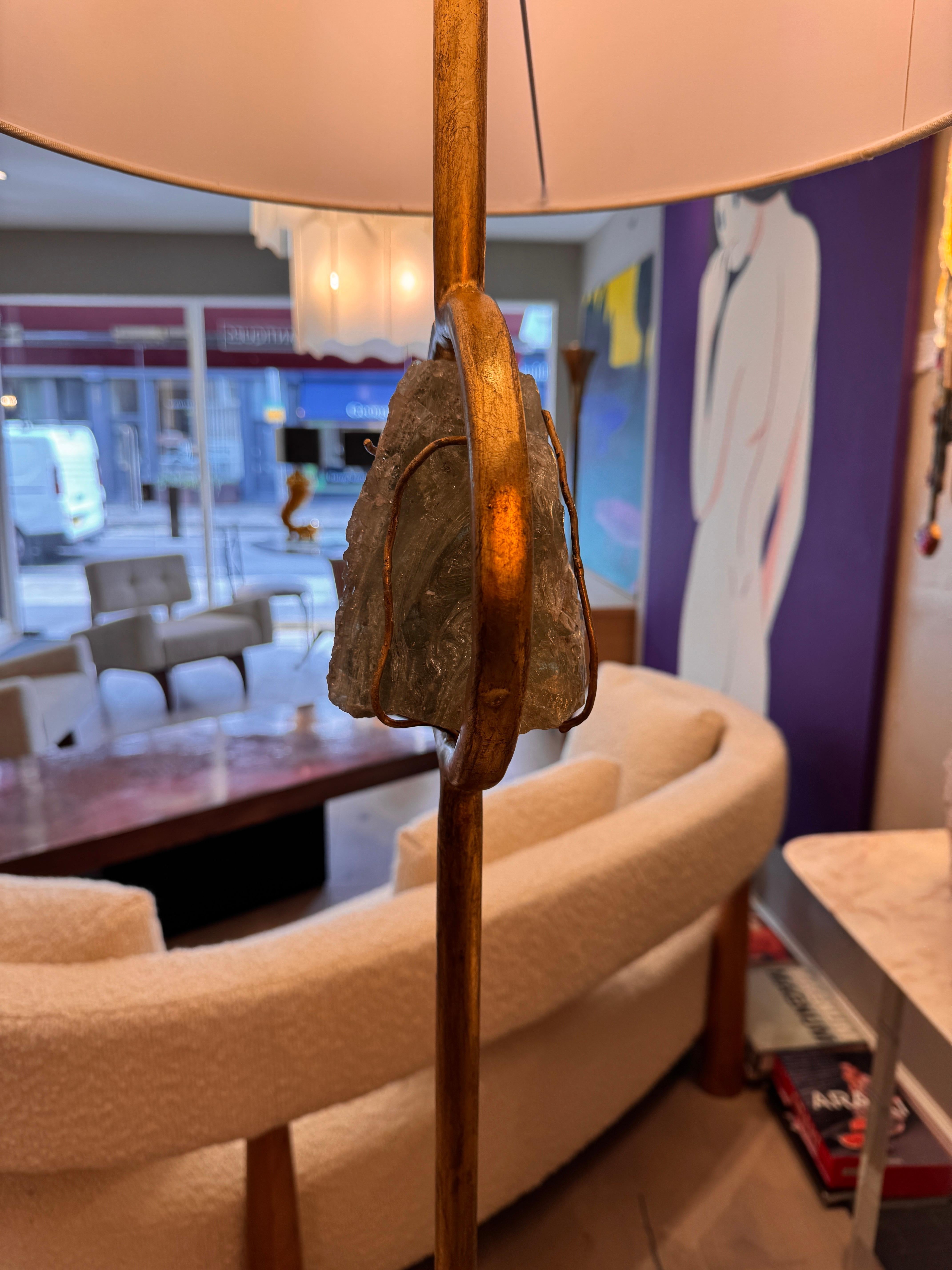 Important lampadaire sculptural en fer doré reposant sur une base circulaire en travertin avec un verre de sauge ciselé à la main au centre, réalisé par le sculpteur florentin Giovanni Banci C1970-1979. 
Hauteur sans l'abat-jour 169cm (67 pouces)