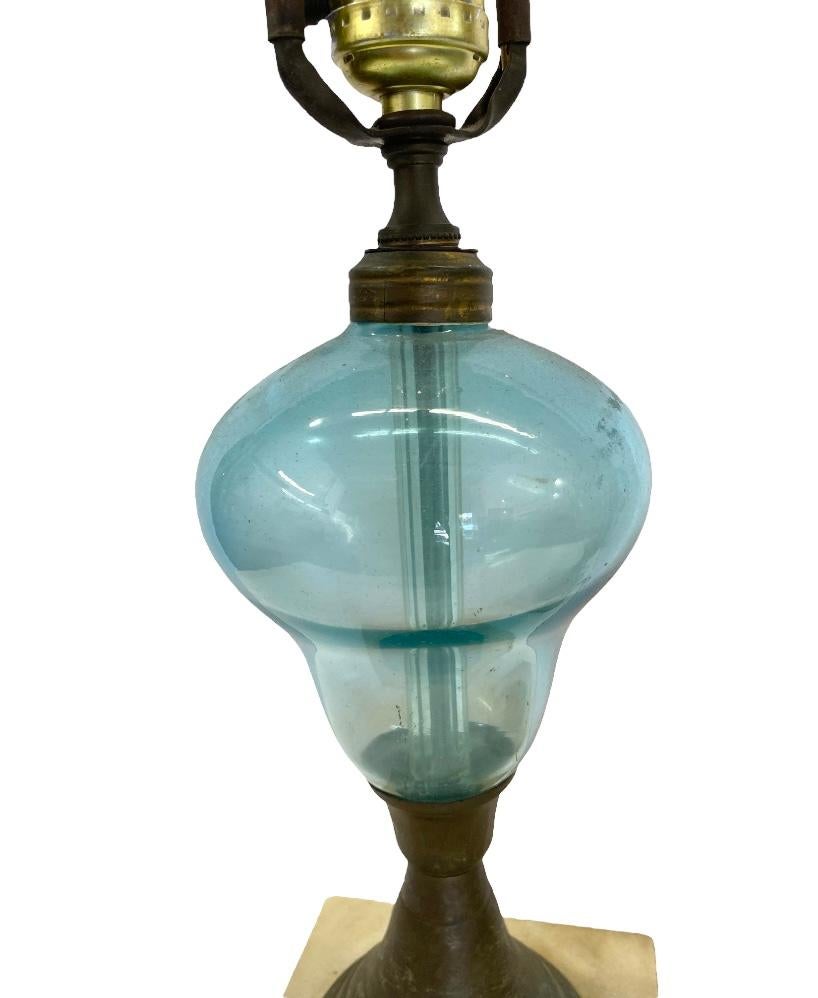 Totally unique and unusual pair of matching table lamps. Executed in blue green bulbous glass, brass, and marble base. These are unrestored and boast an absolutely incredible patina. I have never come across a pair quite like this.