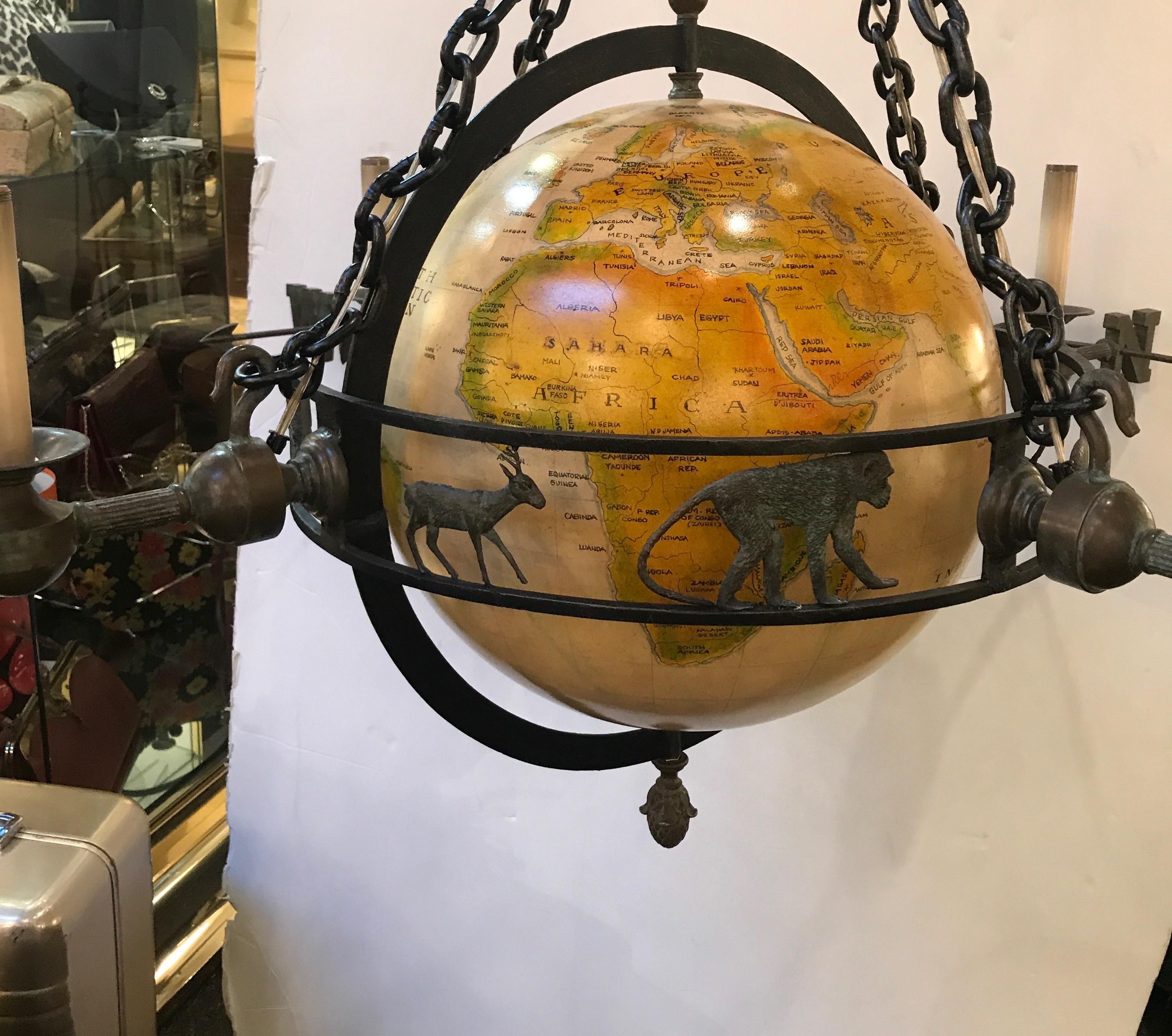 Spectacular chandelier with globe. The patinated bronze frame with four arms, marked north, south, east, west. The open band with animals all around. Very unique fixture that will need a professional electrician to hand due to weight.