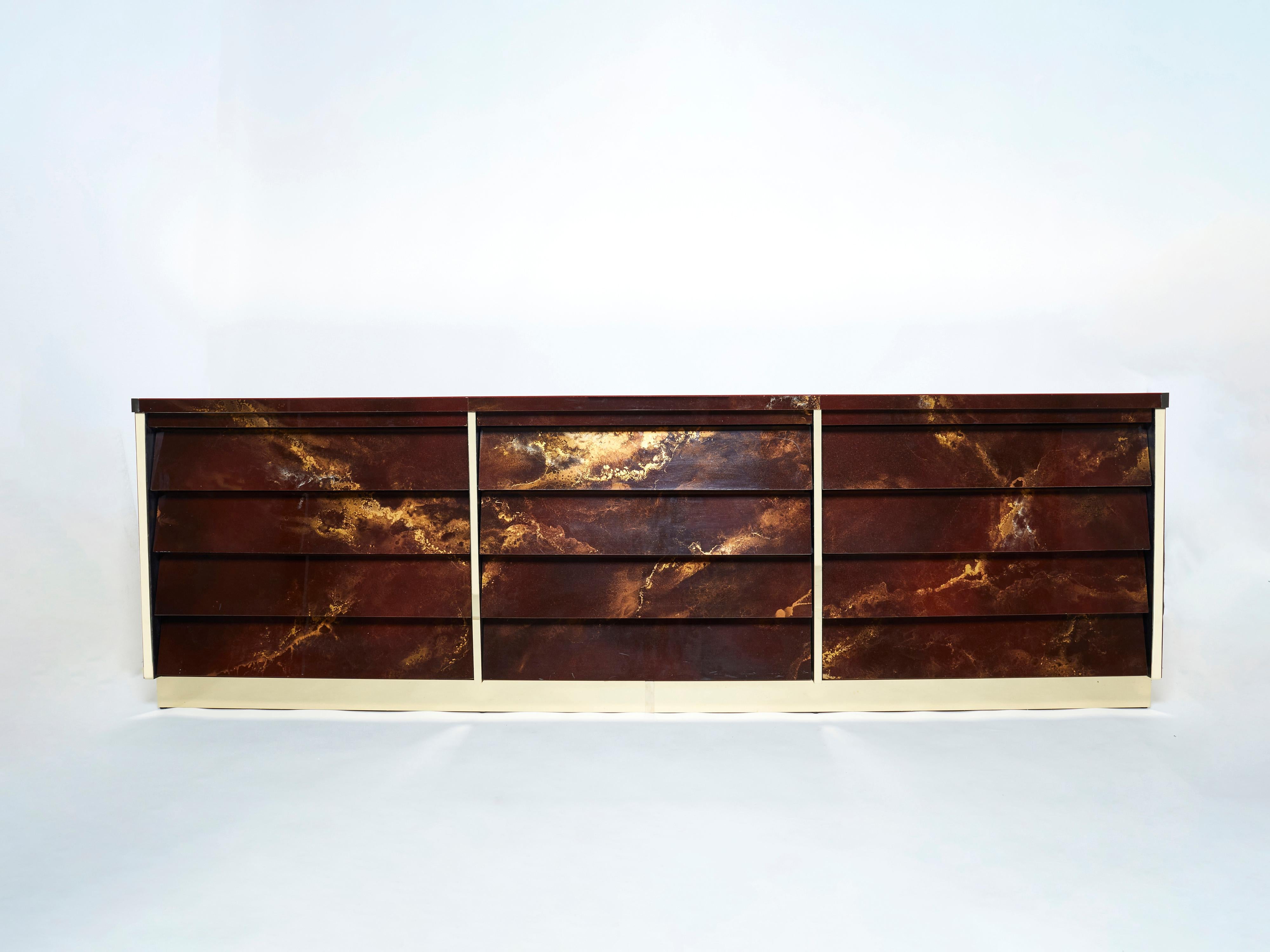 An exciting example of French design firm Maison Jansen’s commissioned pieces. This large sideboard is made from solid oak, lacquered in a rich dark brown and bronze–golden finish. The resulting effect is a beautiful mottling of color around the