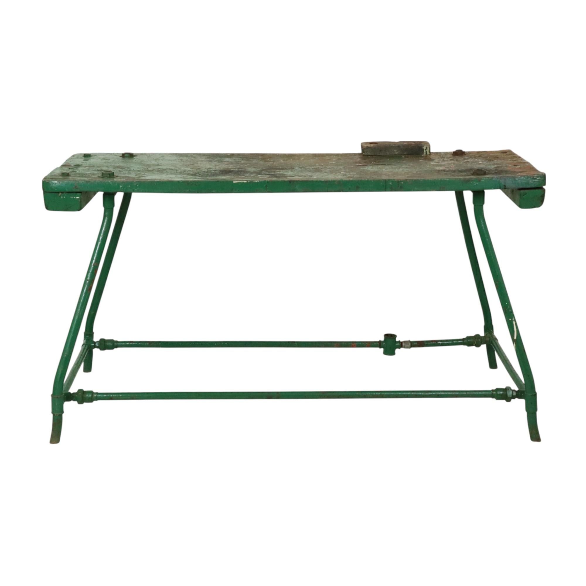 Grande banco da lavoro industriale verde, tavolo da lavoro composto da un piano in legno spesso e da una base in metallo, circa metà del XX secolo.

Il piano ha una bella patina di uso e invecchiamento, la base è realizzata in modo giocoso con