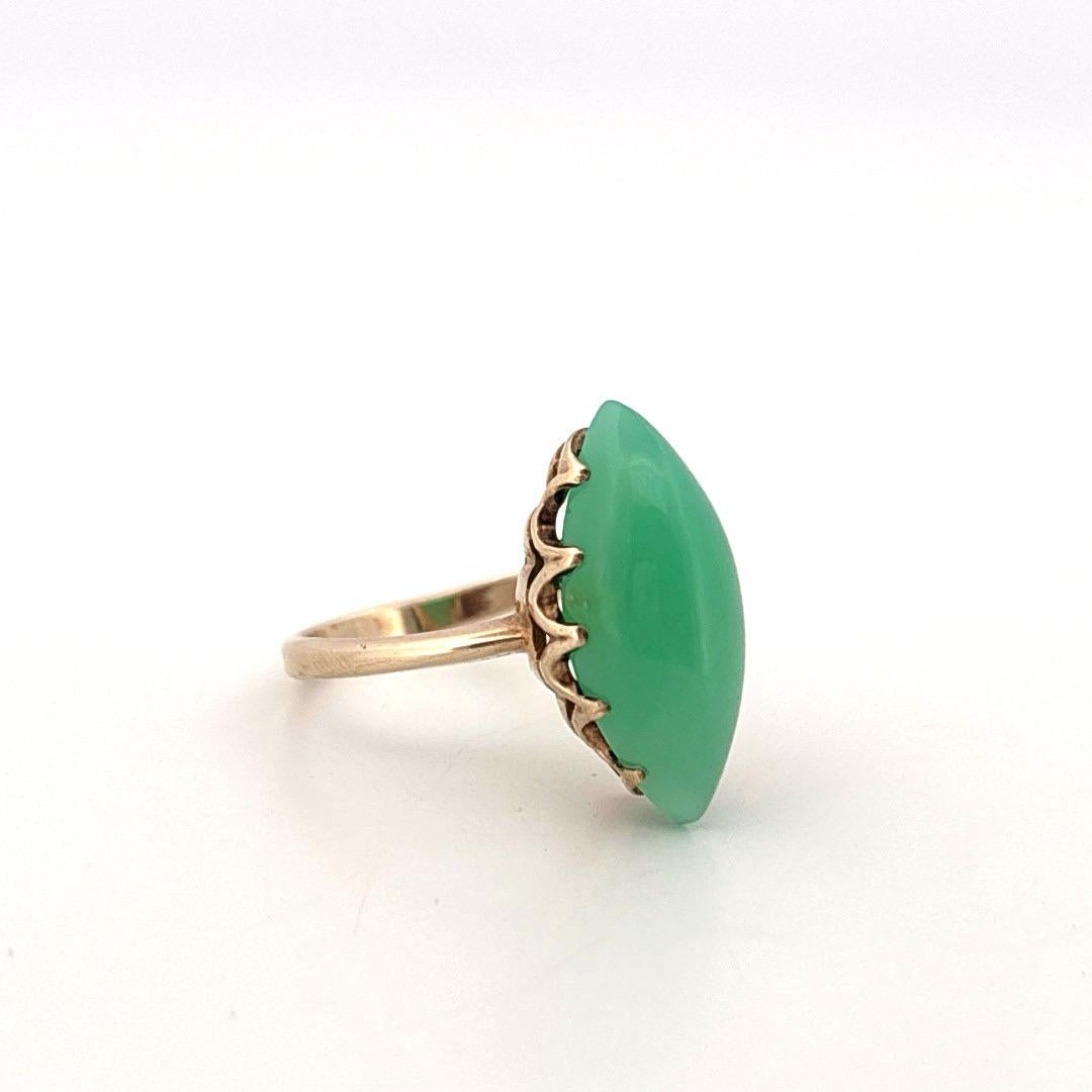 Cette bague vintage présente un onyx vert en forme de marquise serti dans un or jaune 10 carats, alliant élégance intemporelle et couleurs vives. L'onyx poli mesure environ 18,2 mm de long sur 8,8 mm de large. Sa surface lisse et sa teinte verte