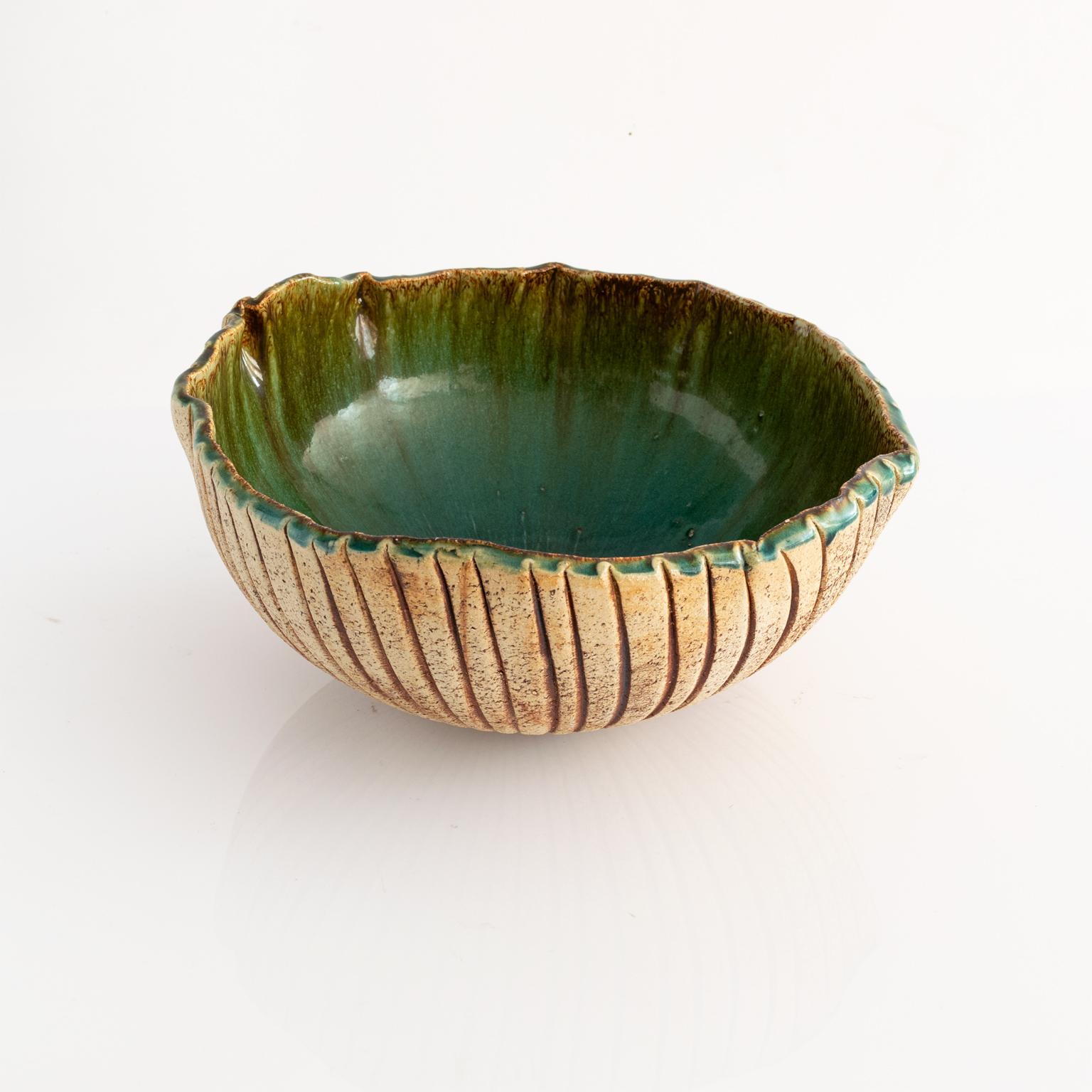Unique hand built ceramic bowl by Bengt Berglund with a molded green glaze on the interior and brown grooves on the exterior side. Made by Gustavsterg, Sweden, circa 1960s.

Measures: Diameter 11