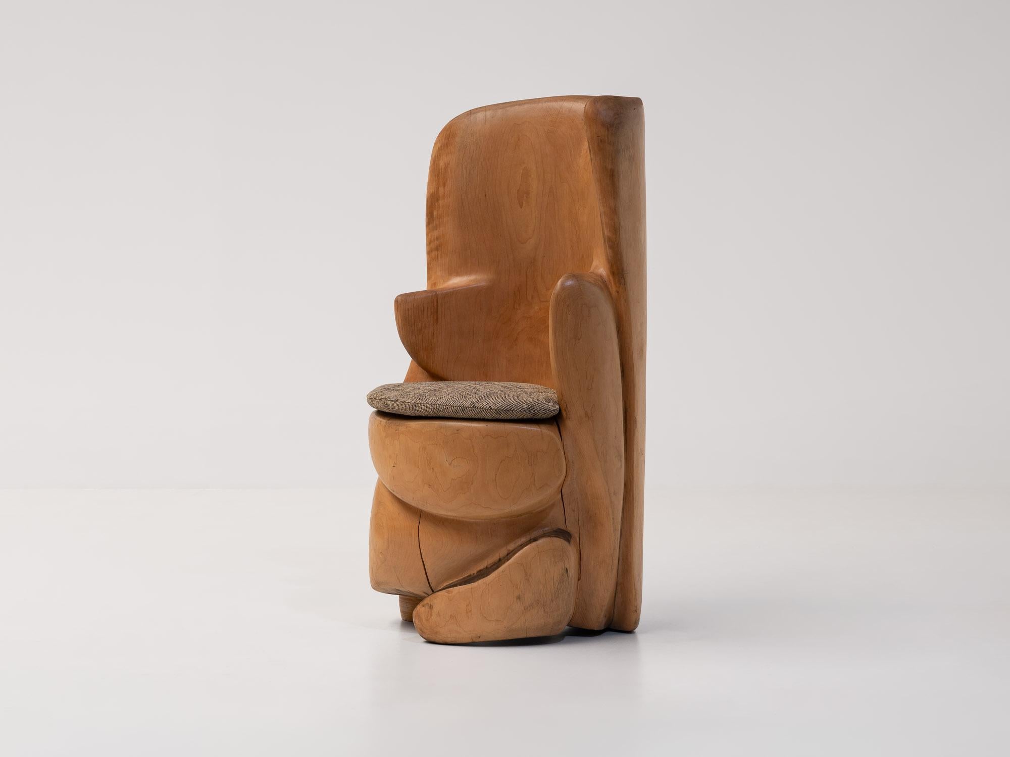 Chaise trône sculpturale exceptionnelle, unique en son genre, provenant d'un atelier d'artisan français, fin des années 1970. Sculpté à la main dans une pièce de bois massif, il présente un dossier généreux et enveloppant aux bords doux et arrondis