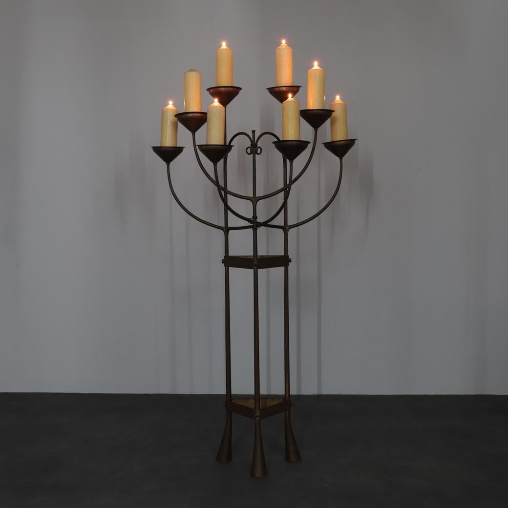 Un candelabro da terra ecclesiastico raro e unico, forgiato a mano e proveniente dalla regione olandese di Amsterdam, realizzato tra il 1925 e il 1938. Radicato nello spirito dell'Art Deco e del Modernismo Liturgico Interbellico, il pezzo combina la