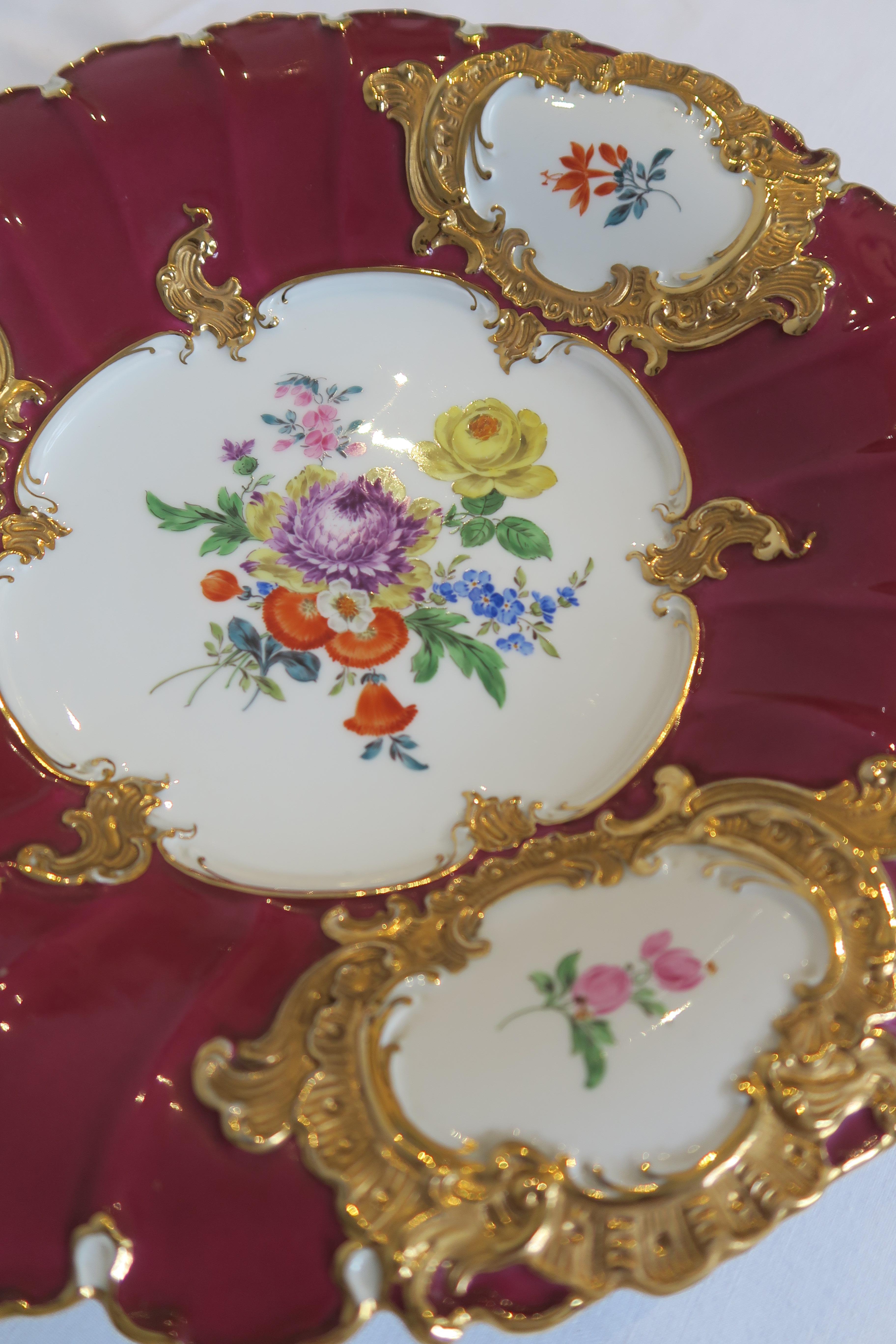 Original fruit bowl/serving bowl by German porcelain manufacturer Meissen featuring beautiful hand-painted floral designs and a gilded ornamental rim. The plate's main colours are white and a vibrant magenta. Excellent condition. No chips, dents or