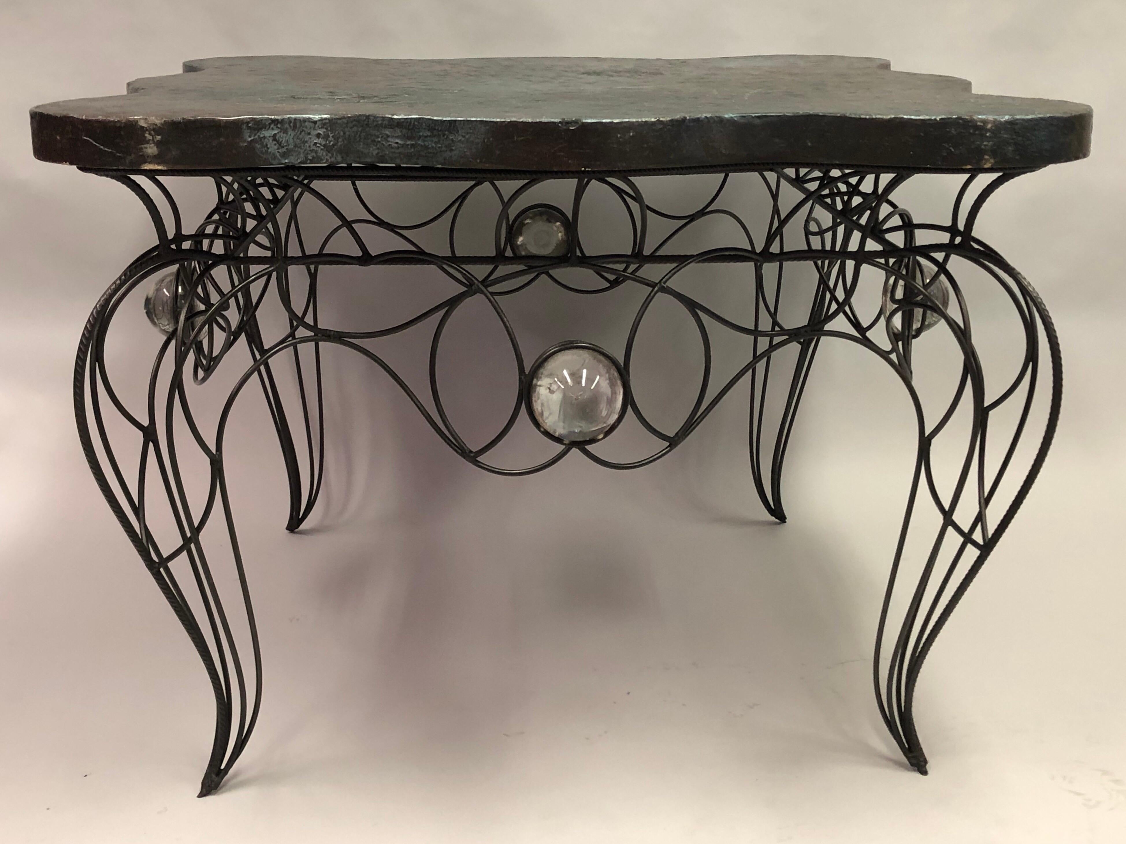 Unique, early, handmade, wrought iron and crystal center or dining table by Andre Dubreuil, 1986.

Handwrought iron frame with four inset hand blown glass balls supporting a serpentine hand painted wood and gesso top.

Literature: 
Andre