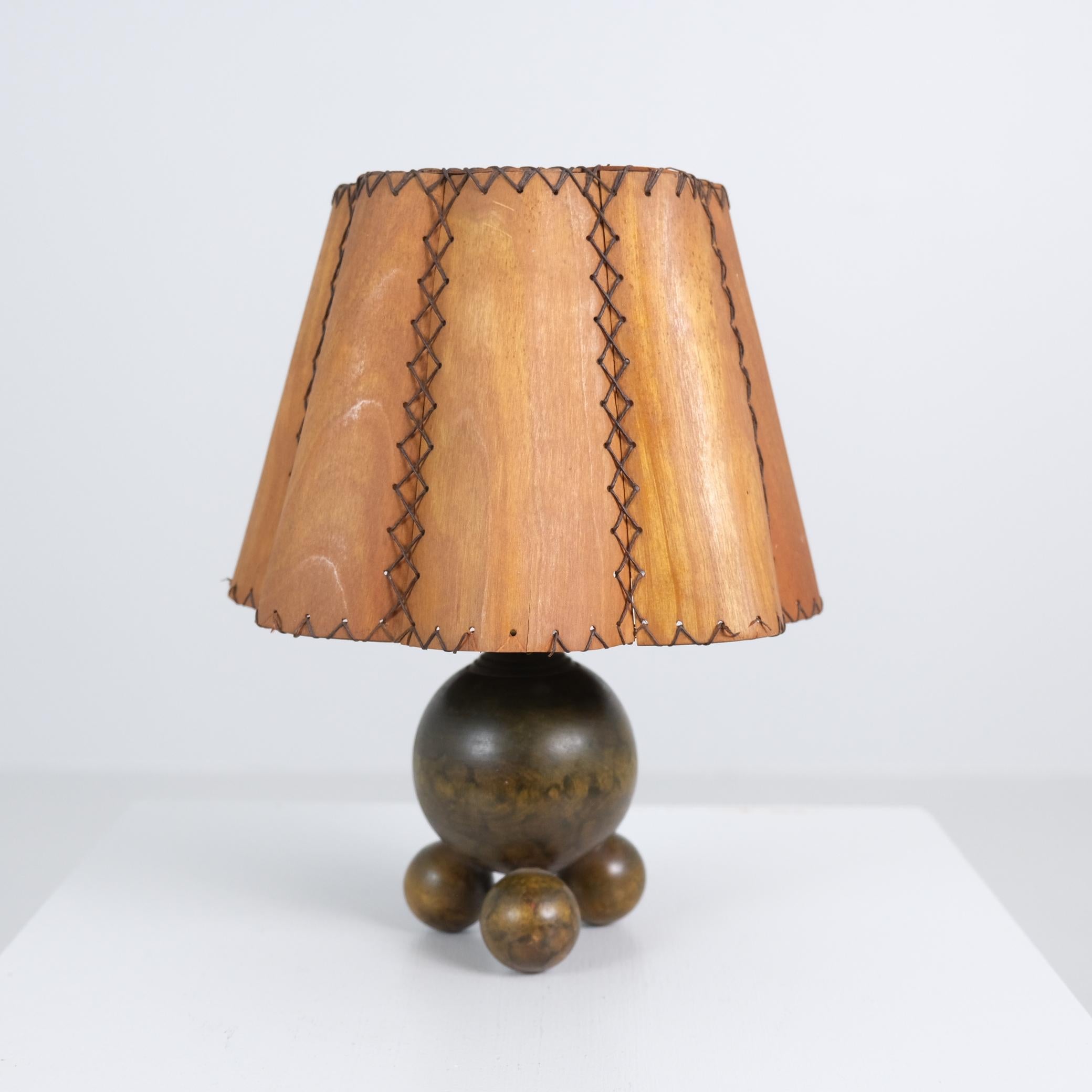 Cette exquise lampe de table finlandaise des années 1940 est un rare témoignage de l'artisanat, de la géométrie et de la simplicité. La base est formée d'une grande sphère centrale reposant sur trois boules de bois plus petites, créant un équilibre