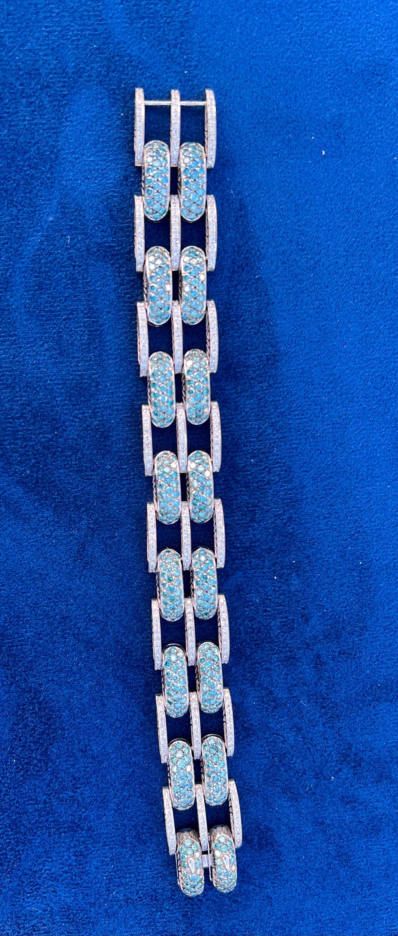A very impressive 22 carat modern wide chain link 18 karat white gold estate bracelet features sparkling fancy blue round brilliant diamonds and round brilliant white diamonds. The contrast between the two diamond colors is very striking!  Bracelet