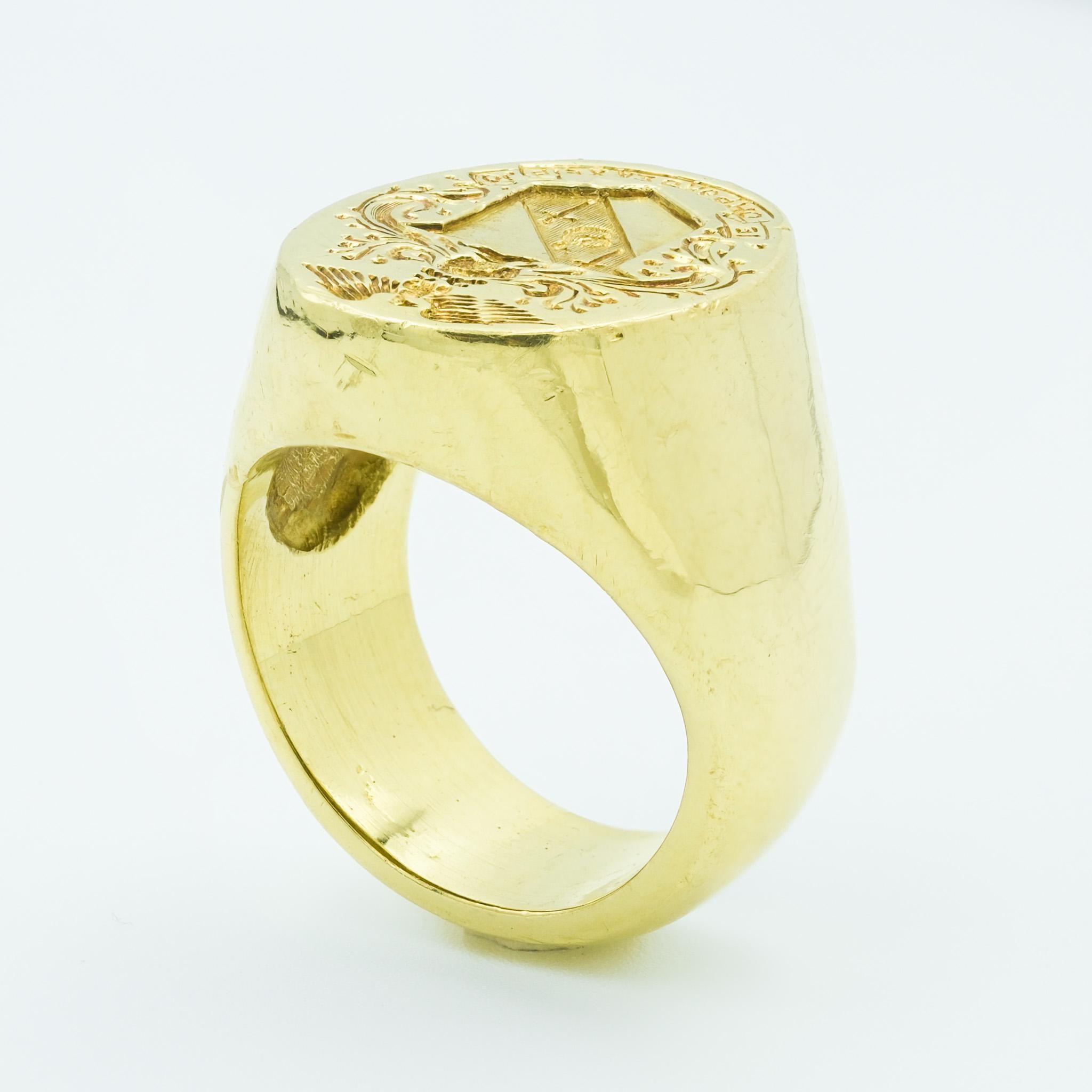 This robust 18 karat yellow gold signet ring is a statement of bygone heritage and strength - weighing in at a substantial and hefty 49.1 grams. The ring features a strikingly detailed crest and an eagle in mid-flight, often symbolic of power and