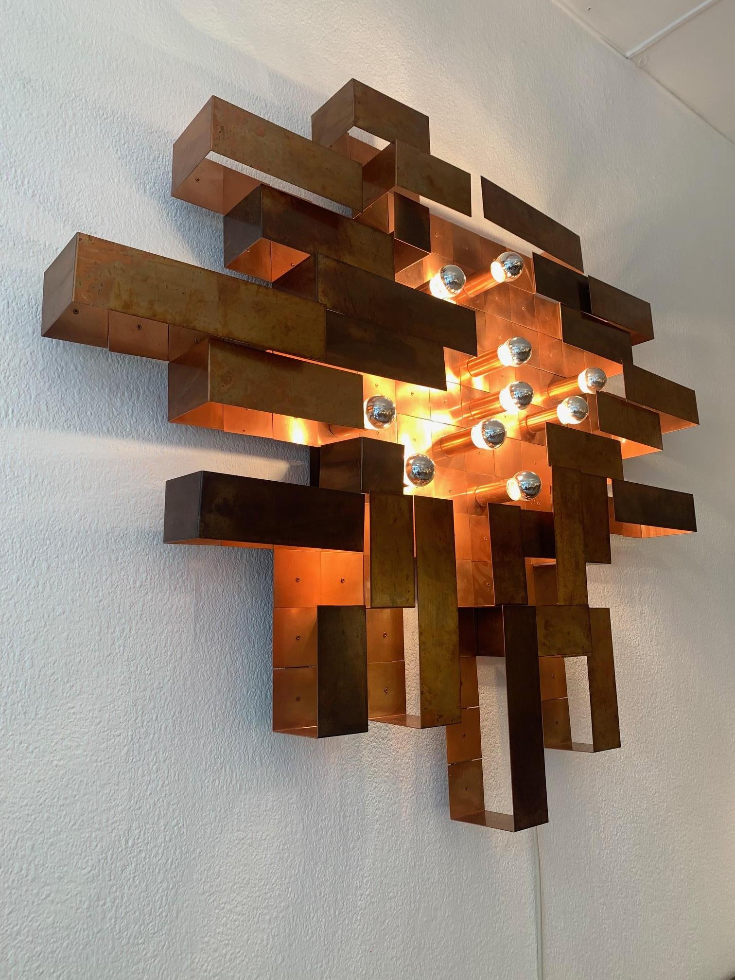 Unique, made on order, huge copper asymetrical brutalist wall lamp ca. 1970's
Probably made in Switzerland, highly decorative
10 E14 standard bulbs (mirrored) 
Beautiful patina (oxydation on copper)
Comes with an iron frame to fix on the wall.