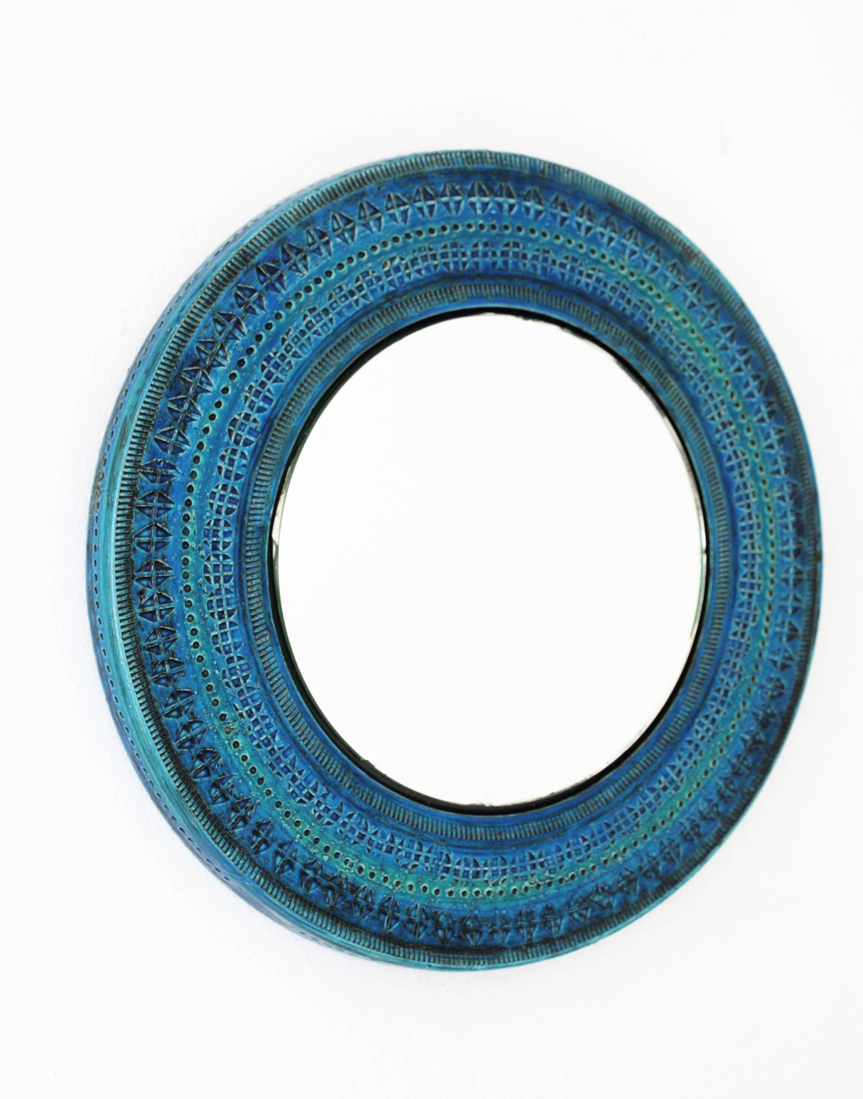 Italian handcrafted blue terracotta glazed ceramic mirror with hand-carved geometric designs in a vibrant turquoise and cobalt blue colors. Rimini blue collection designed by Aldo Londi for Bitossi, Italy, 1960s. Glass dimensions: 21.5cm