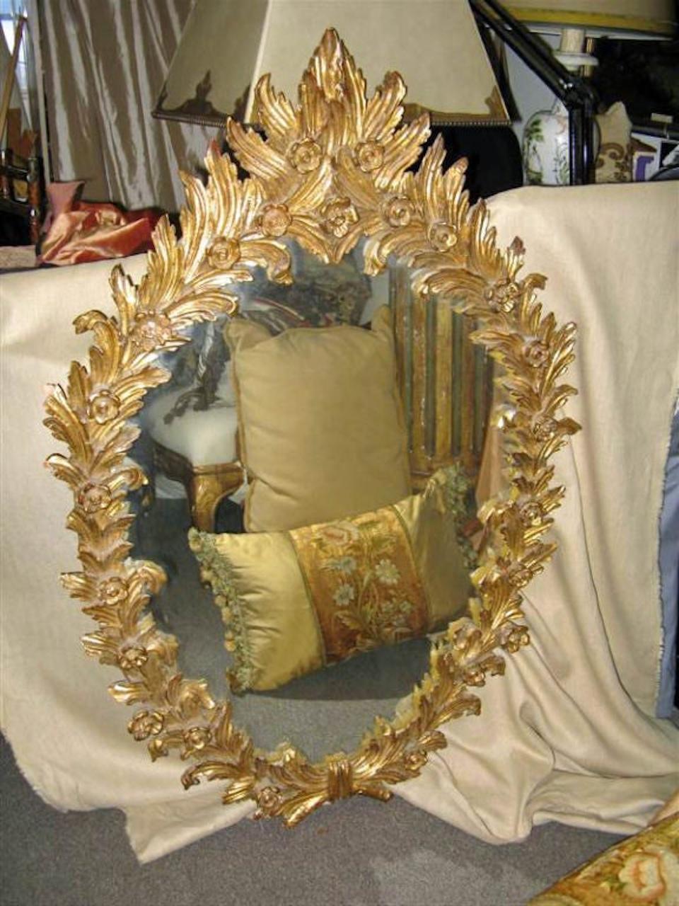 Exquis à tous points de vue, ce miroir en bois doré des années 1930 est composé de feuilles d'acanthe et de petites fleurs sculptées. Imaginez ce miroir ovale unique dans votre salle d'eau ou votre petite entrée.