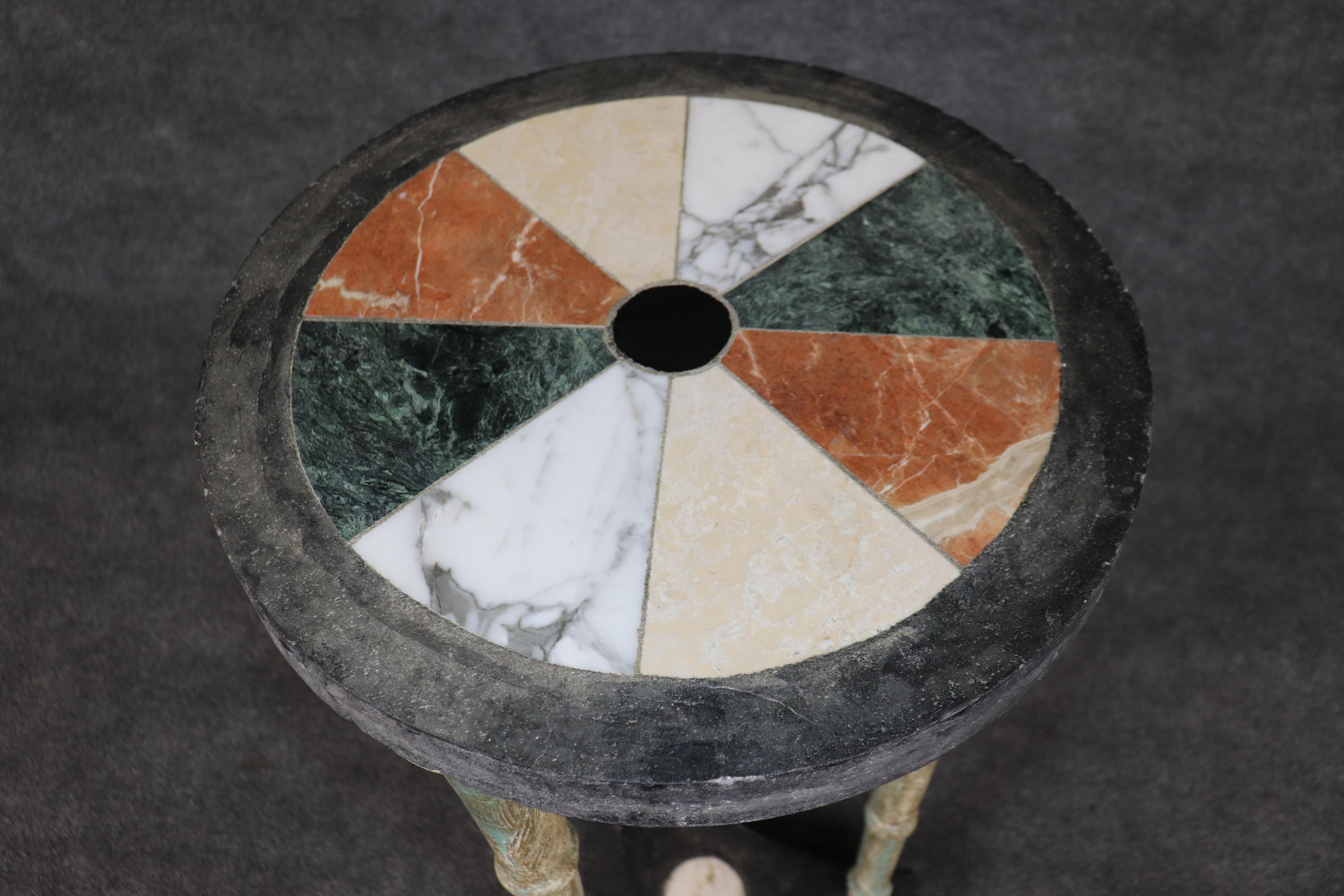 Si tratta di un esemplare unico e superbamente lavorato o di un tavolino da piedistallo in pietra dura neoclassica. Il tavolo è caratterizzato da un'infarinatura multicolore di esemplari di marmo intarsiati nella base in metallo patinato anticato.