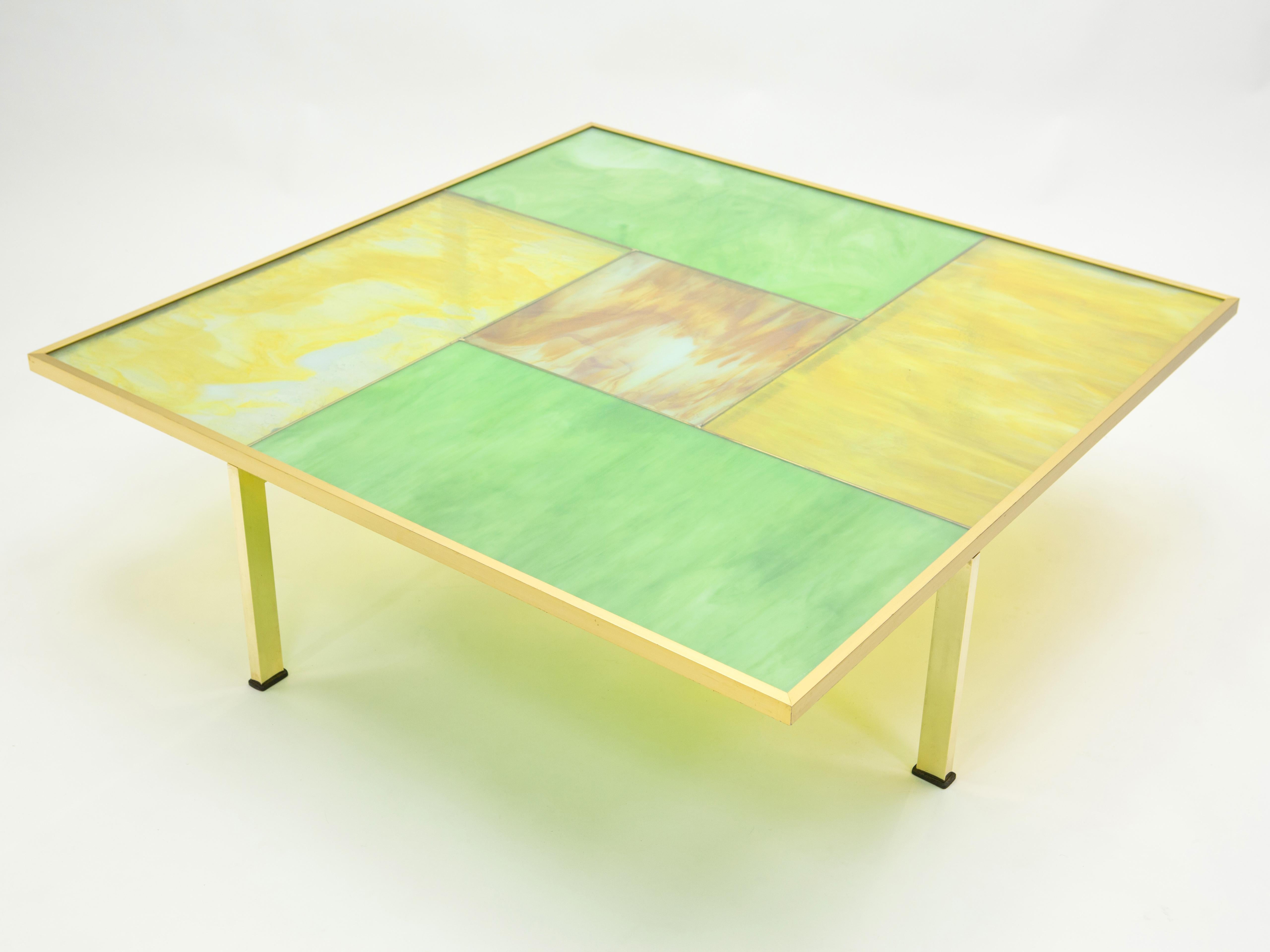 This unique large square coffee table was created in Murano, Italy, in the late 1960s. Made of blown Murano stained glass, protected by a transparent glass on top, framed in a brass frame, and laying on brass feet. The glass reflections and colors