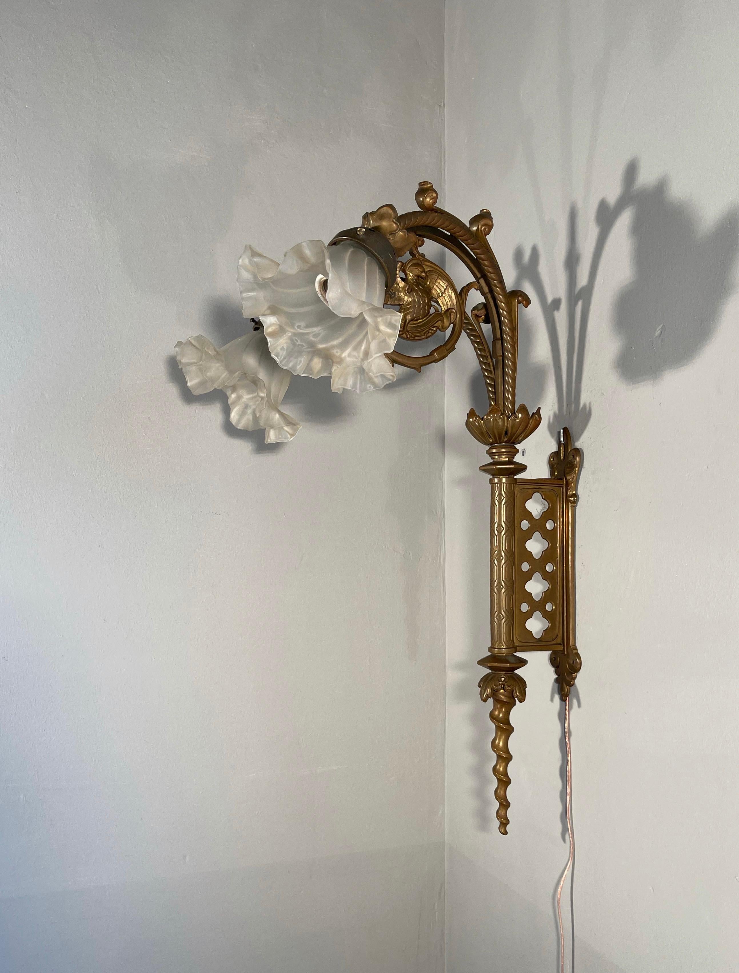 Unique Gothic Revival light fixture for wall mounting.

This antique Gothic wall sconce with two flowery glass shades is another one of those antiques of which you immediately realize that it ticks all the boxes. Perfectly handcrafted in the
