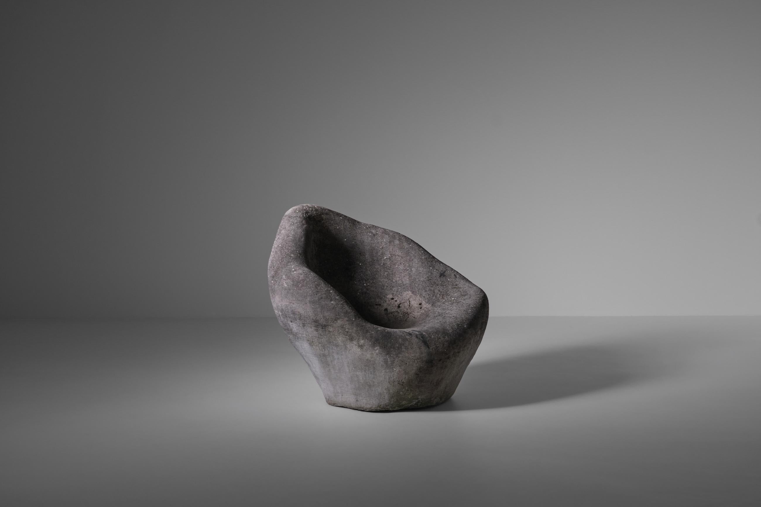 Unique large faux concrete garden chair, France ca. 1970s. Sculptural amorphous shaped chair made out of fiberglass with a raw micro stone finish. The base material of the chair is made of solid styrofoam which makes the piece very strong and quite
