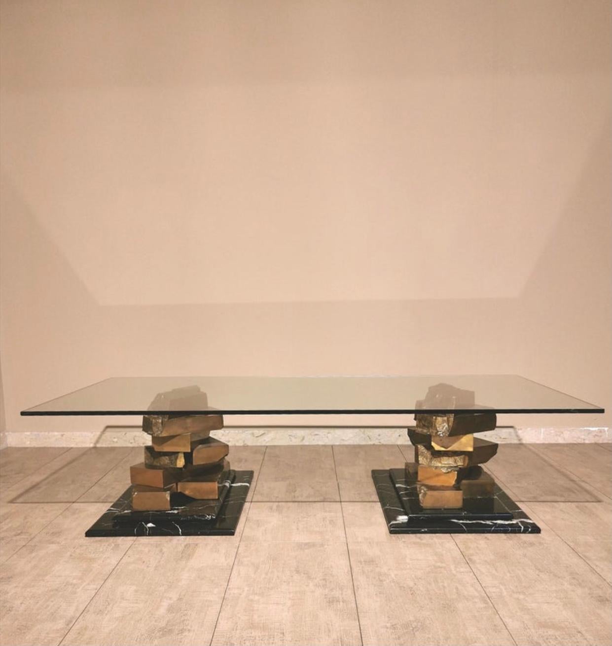 An exceptional and rare large Italian coffee table sitting on two rectangular Marquina marble bases with two sculptures in bronze and a large glass top. A truly outstanding piece of functional art & design. This substantial coffee table weighs a
