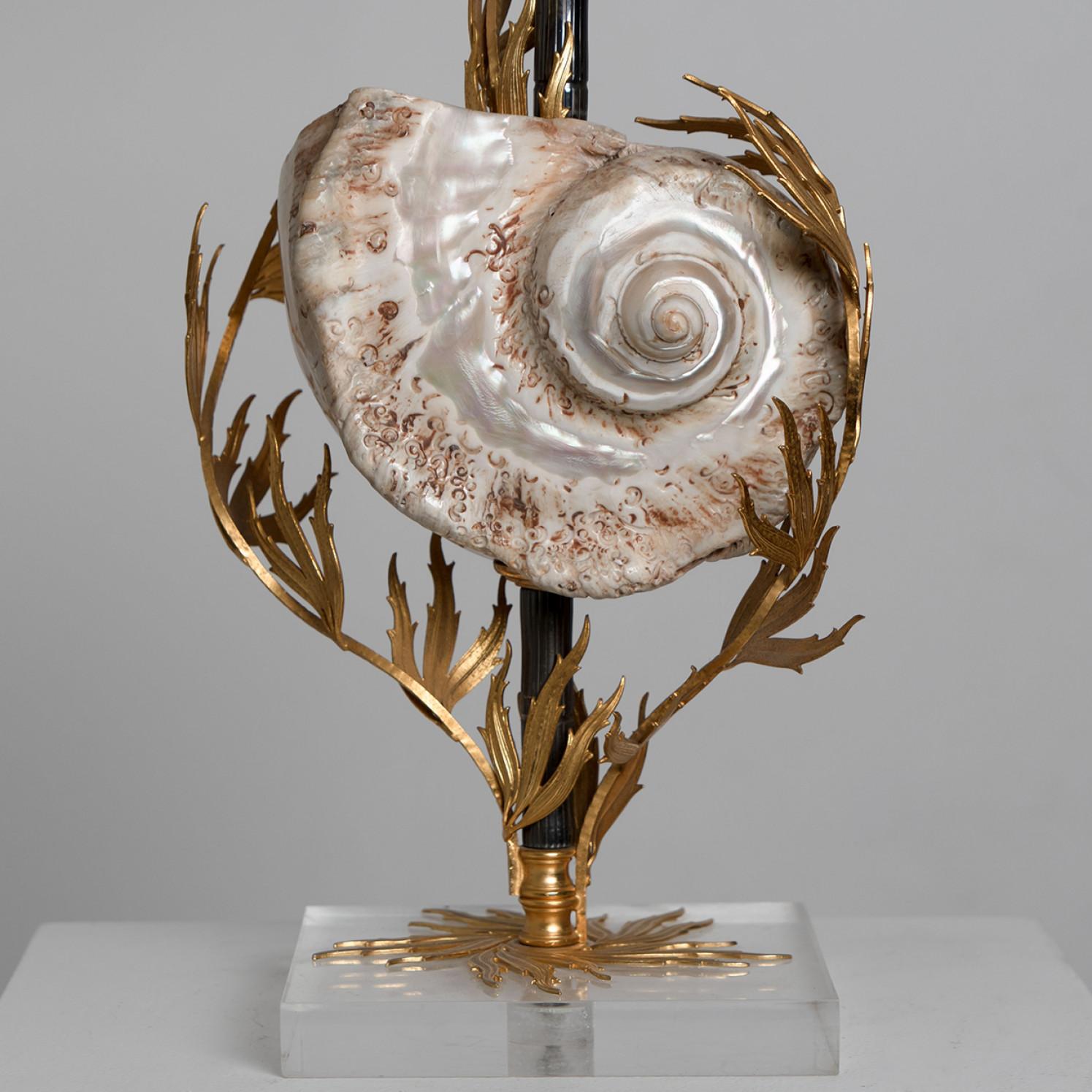 An unique table lamp with a large real shell on the base. The lamp is ornamented with beautiful brass coral details and comes with a handmade semi-shiny lampshade which gives a warm light.
The lamp is manufactured in Italy, Europe.
This beautiful