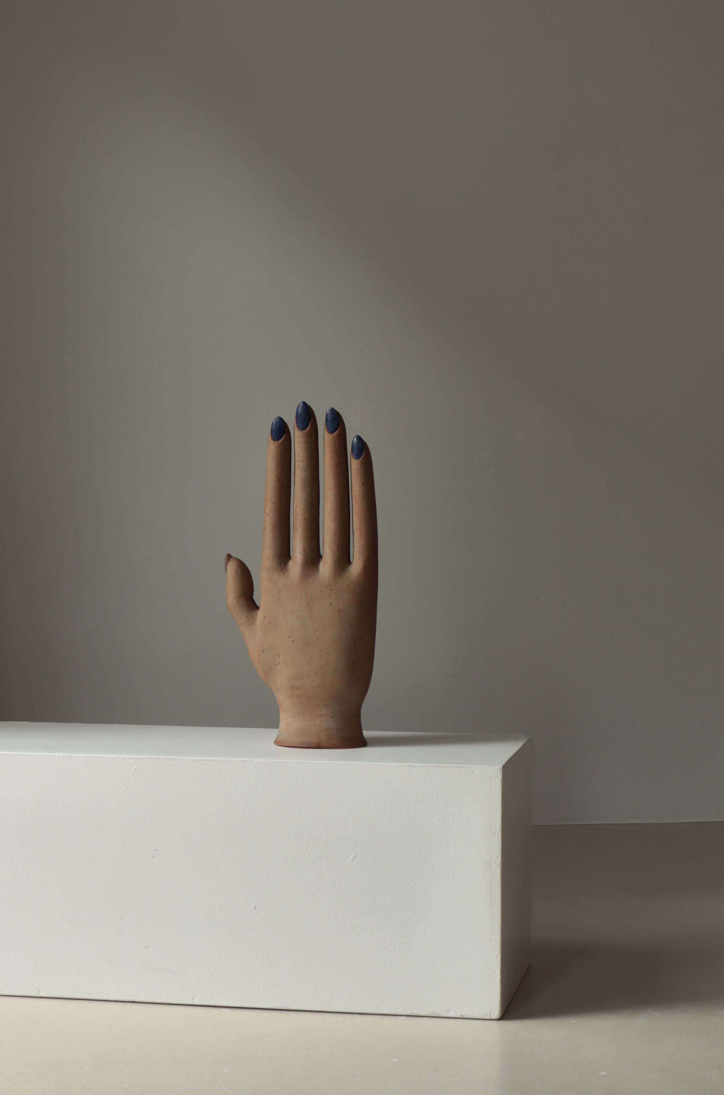 Une étonnante sculpture unique en grès modelée en forme de main de femme avec des ongles émaillés en bleu. Fabriqué par l'artiste danois Finn Lynggaard dans son propre studio dans les années 1970. Monogramme et signe estampillés. I.L.A. 