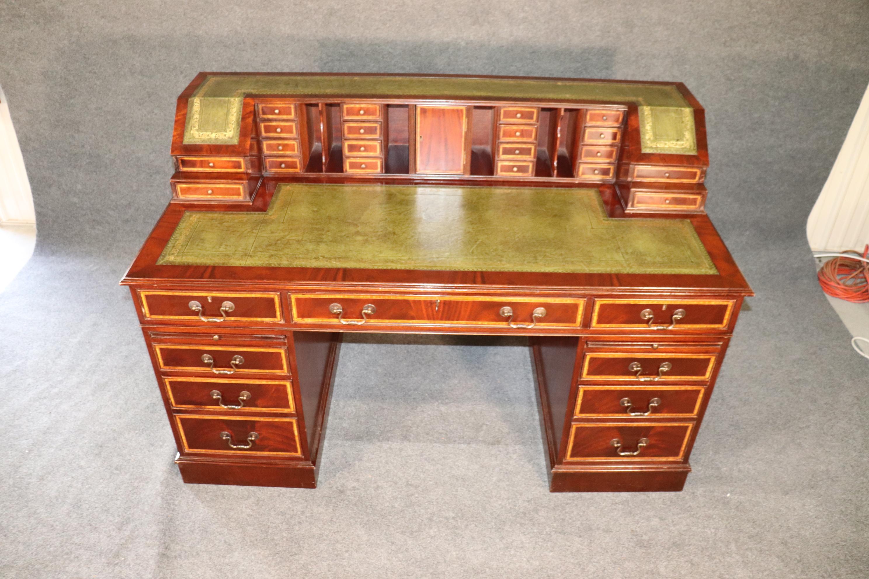 This is a beautiful English-made desk that comes apart into four pieces and has beautiful leather with gold tooled embossing on the top's surface. There are numerous drawers and storage areas on the superstructure. The desk dates to the 1950s era