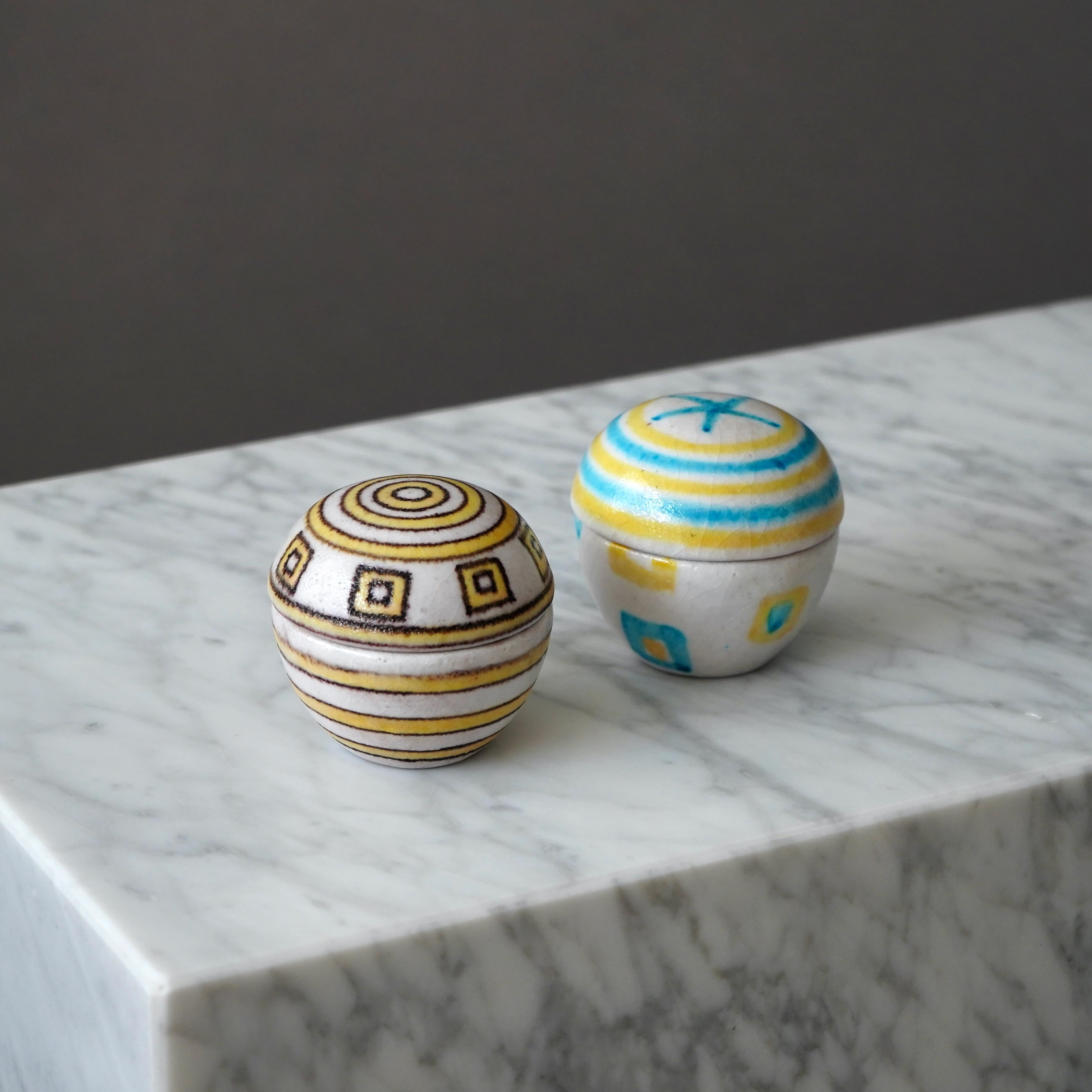 Two beautiful and unique lidded boxes with amazing lava-like glaze.
Made by Guido Gambone in Florence, Italy, 1950s.

The box with brown and yellow glaze is in excellent condition. But the box with blue and yellow glaze has a hairline crack.

Marked