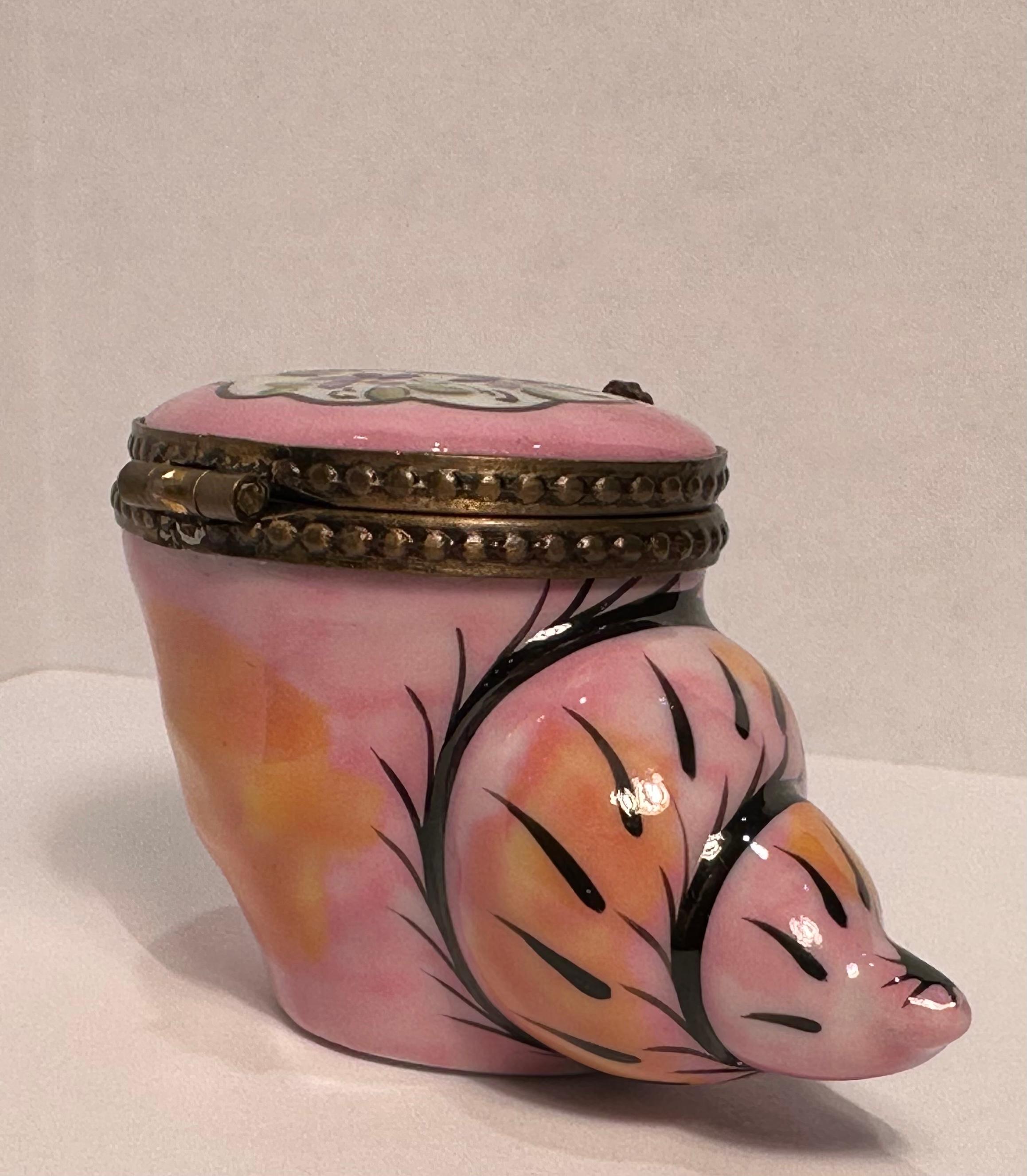 Collectible and very unique, Limoges porcelain miniature trinket box is handmade and hand painted in France. It features a beautifully hand painted pink and orange sea shell with black accents and pretty hand painted lavender and purple forget me
