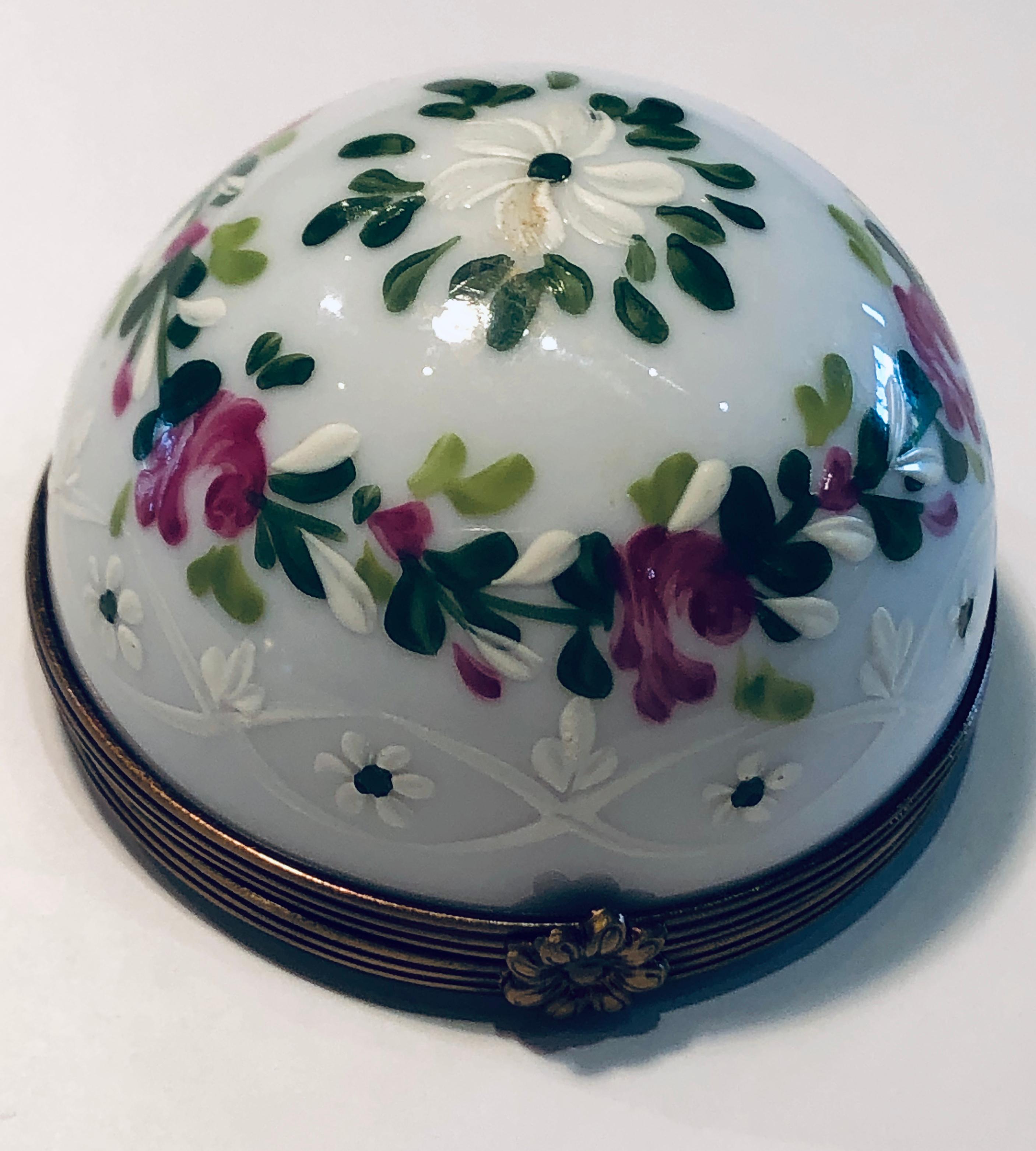 Very unusual, Limoges porcelain miniature dome is handmade and hand painted with a rose motif in pink, green and white. Dome opens to reveal a beautiful bouquet of three dimensional handmade roses on a background painted with roses. Box features