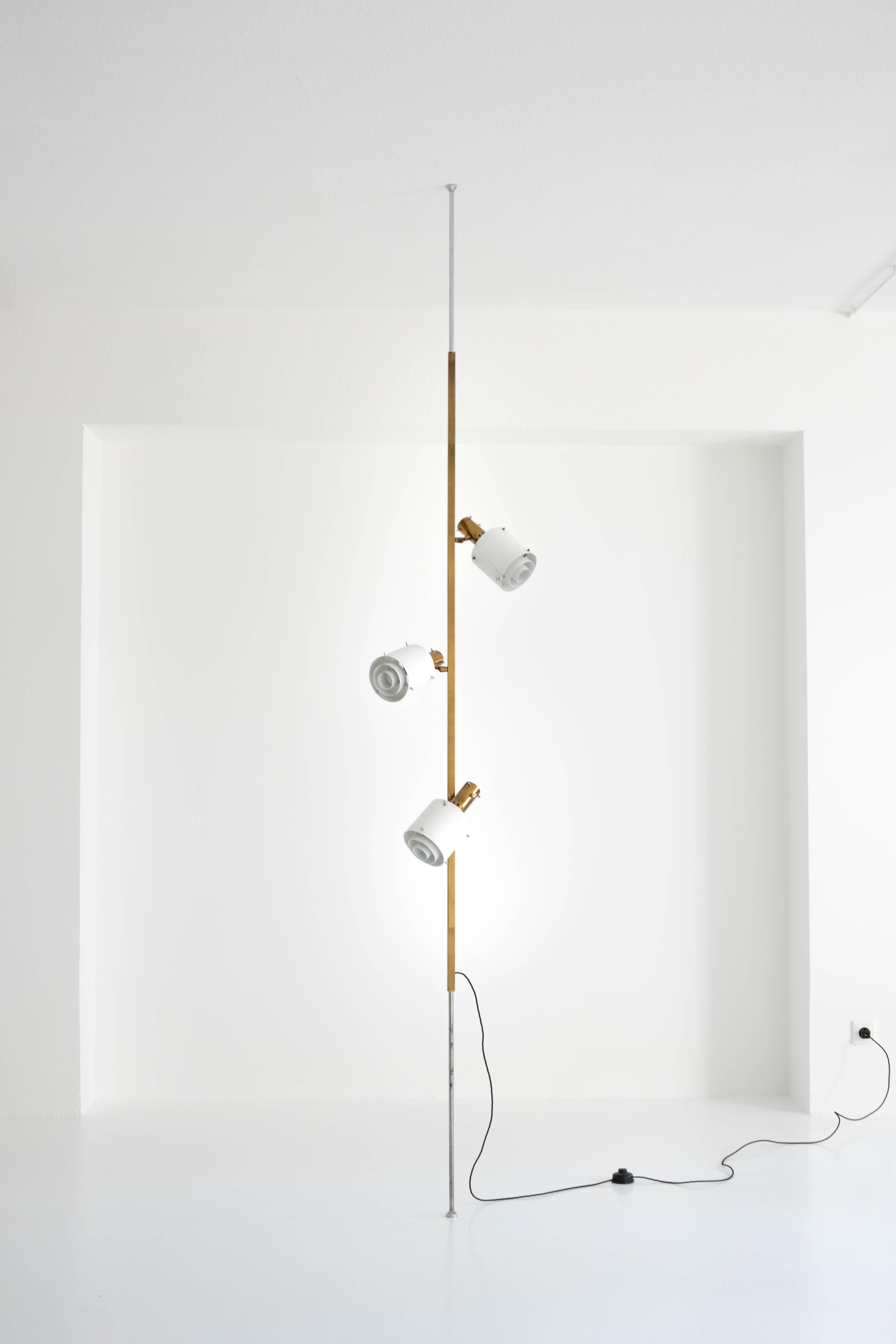 Unique and rare italian luminaire that is clamped between the ceiling and the floor by an internally seated spring.

the two outer rods touching the floor and deck are made of chrome-plated round steel tubing, with not much left of the