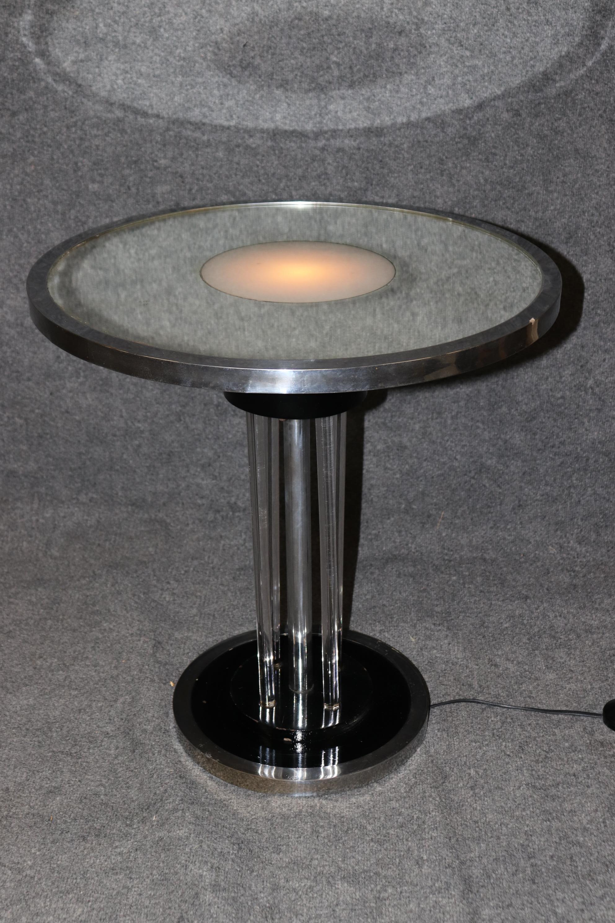 This is a superb and unique custom-made Art Deco or machine Age style table made to display something you're trying to highlight or showoff a bit. The table is made of brass and chrome and has a step button to turn on the light to brighten your