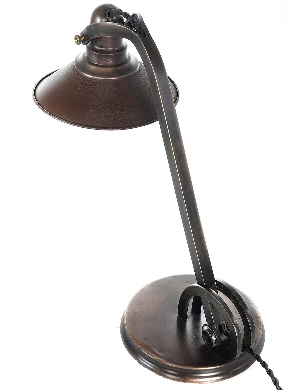 This table lamp is a first for us. Its unique and very well designed. It could be an important designer but is unsigned. The Nautilus shell inspired articulating joint is elegant as well as functional. The tin shade has the original crackle finish