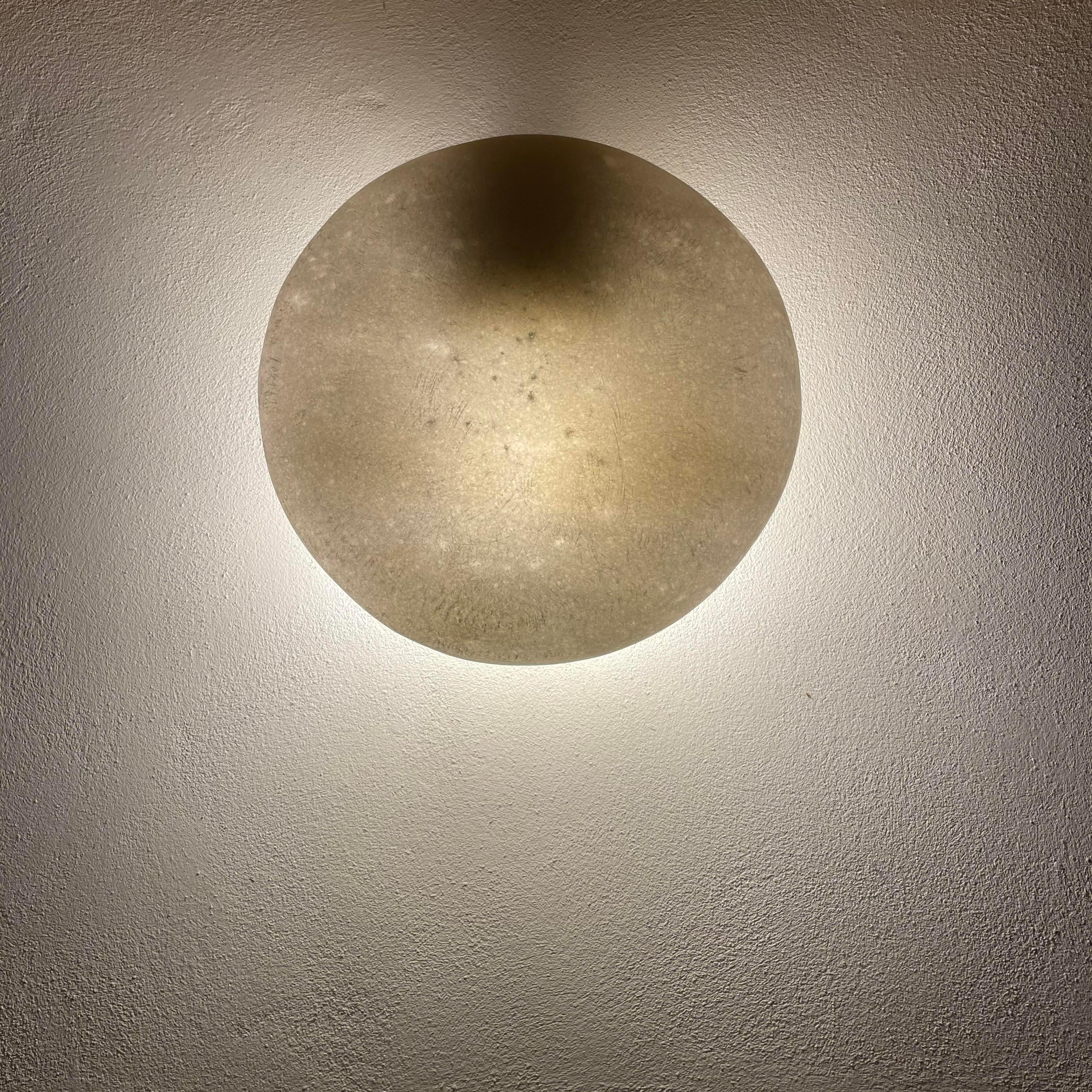 Unique marble wall lamp by Tom von Kaenel
Dimensions: Ø 32 x D 14 cm
Materials: Marble

All the artworks of Tom von Kaenel are unique, handcrafted by himself.
The stones all come from the surrounding marble quarries of the island. The Naxian