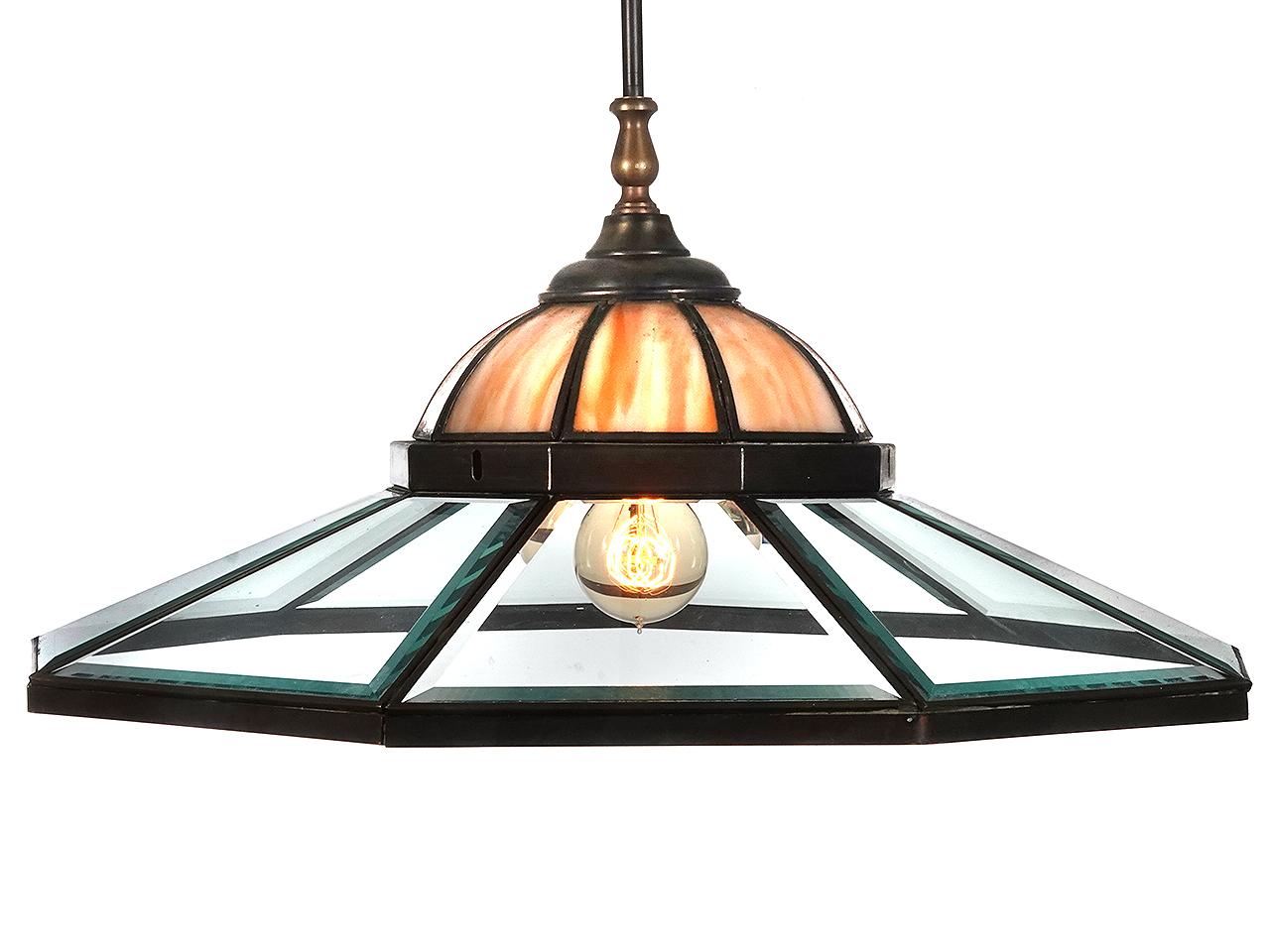 This matching pair of lamps are very unique and we have never found another example like them. It uses 2 different types of glass. The top dome is a cream and amber slump glass with 9 panels. That dome is surrounded by 9 panels of thick clear glass
