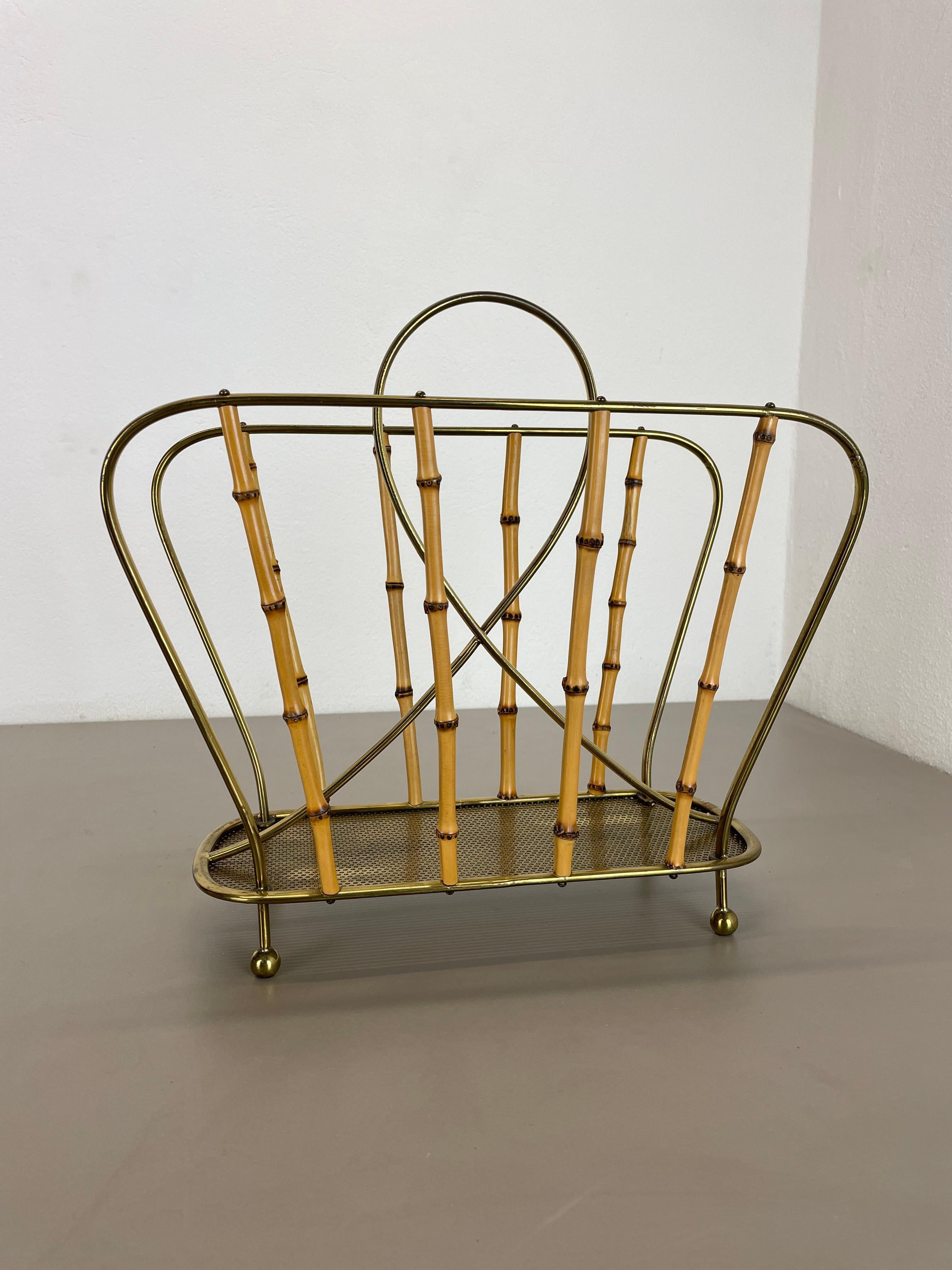 Article: magazine holder stand element

Origin: Austria

Age: 1950s

This original vintage Auböck style magazine holder stand was produced in the 1950s in Austria. It is made of brass, metal and bamboo with metal base in hole pattern optic combined