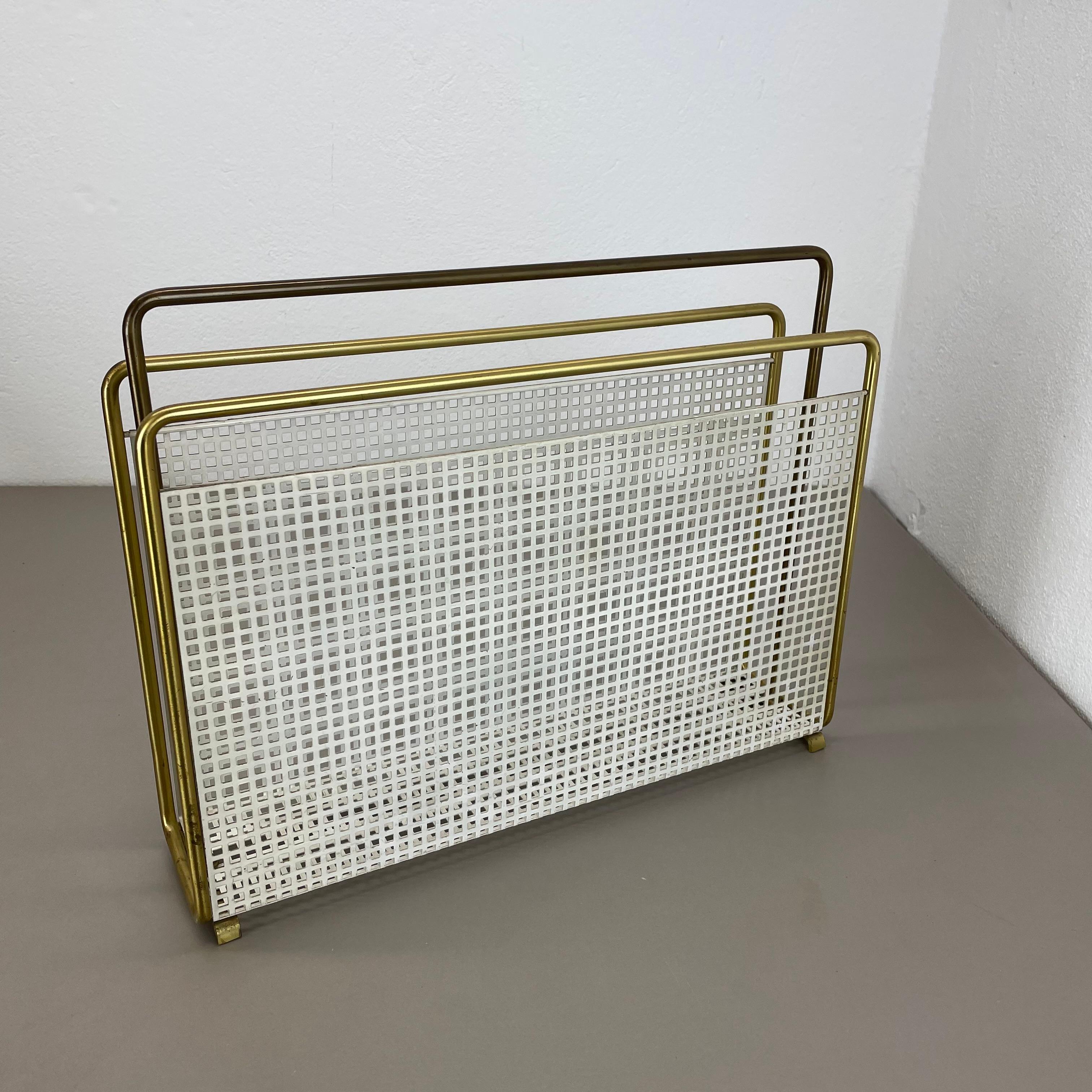 Artículo: elemento de soporte revistero

Origen: Austria

Edad: años 50

Este original mategot vintage  El revistero de estilo se fabricó en la década de 1950 en Austria. Está fabricado en latón y metal con laterales portacargadores metálicos en