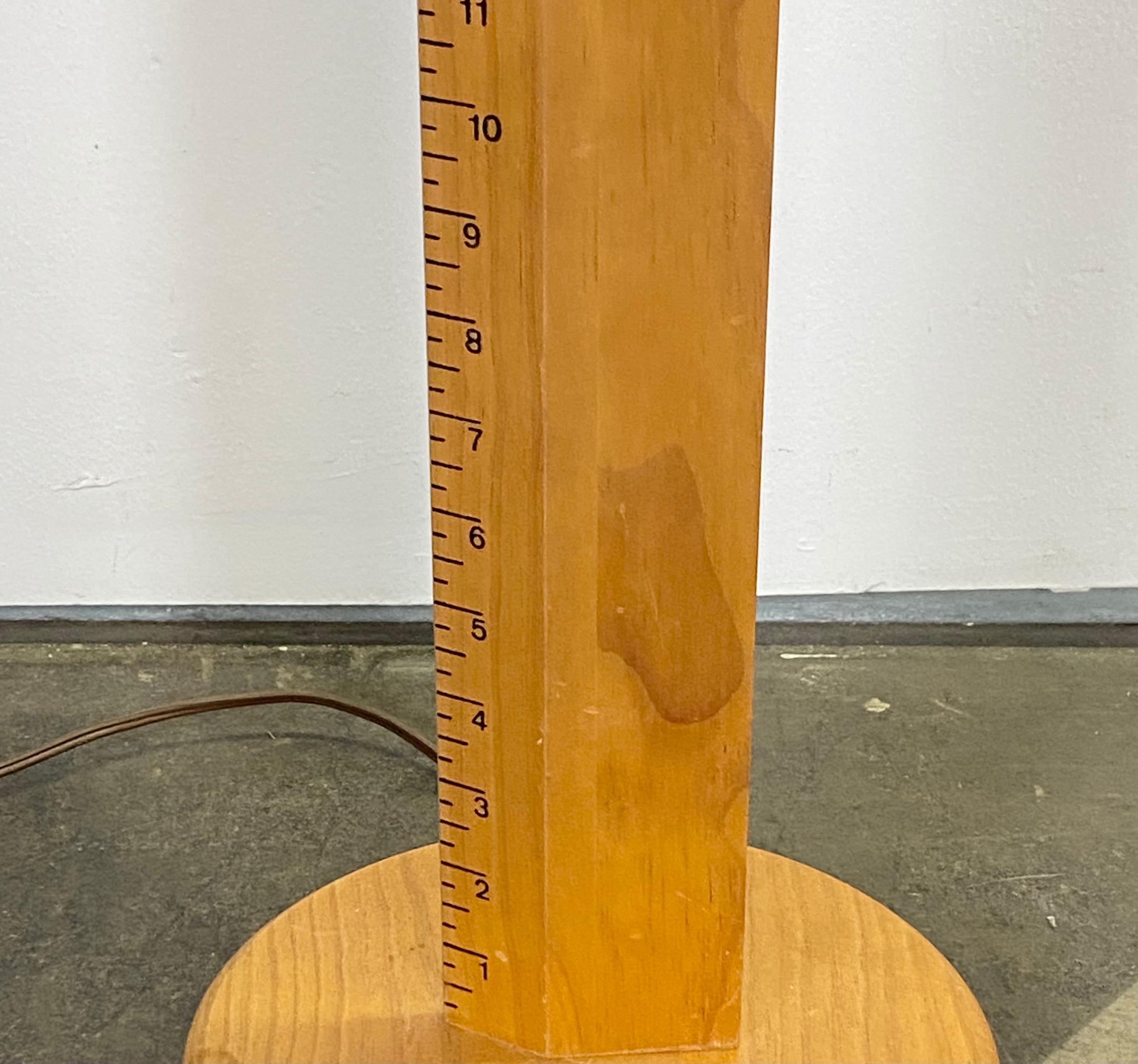 Cool and unique floor lamp with measuring stick. Appears to be made or ash wood with black interval markings. Works great and accommodates modern bulbs. Outfitted with brand new shade. Motif makes it a cool lamp for the study or workshop, or perhaps