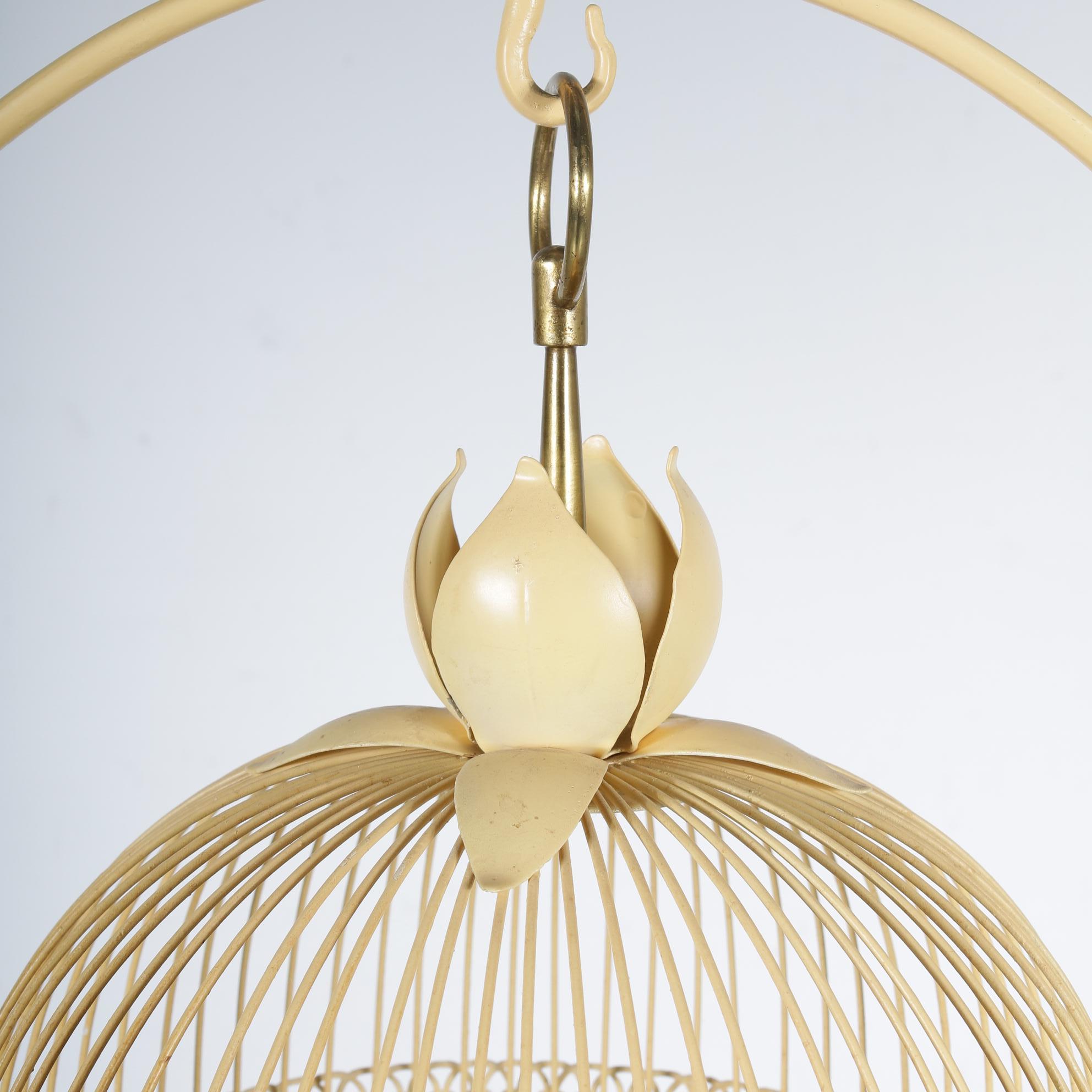 A beautiful metal bird cage on a highly decorative stand, manufactured in France, circa 1950.

This eye-catching piece is made of yellow lacquered metal in a wonderful style, designed with great eye for detail. The cage itself has a flower shape