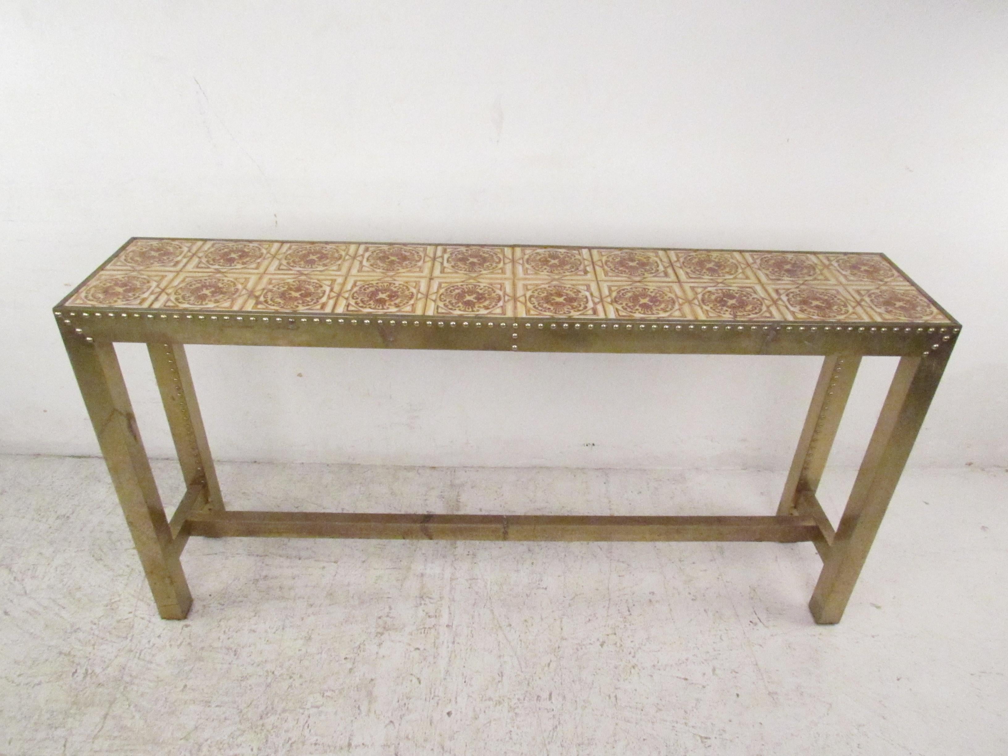 This beautiful vintage modern console table boasts a unique top with decorative tiles and a brass studded frame. An unusual piece that looks great behind the sofa, in the entry way, or in the hallway. Please confirm item location (NY or NJ).