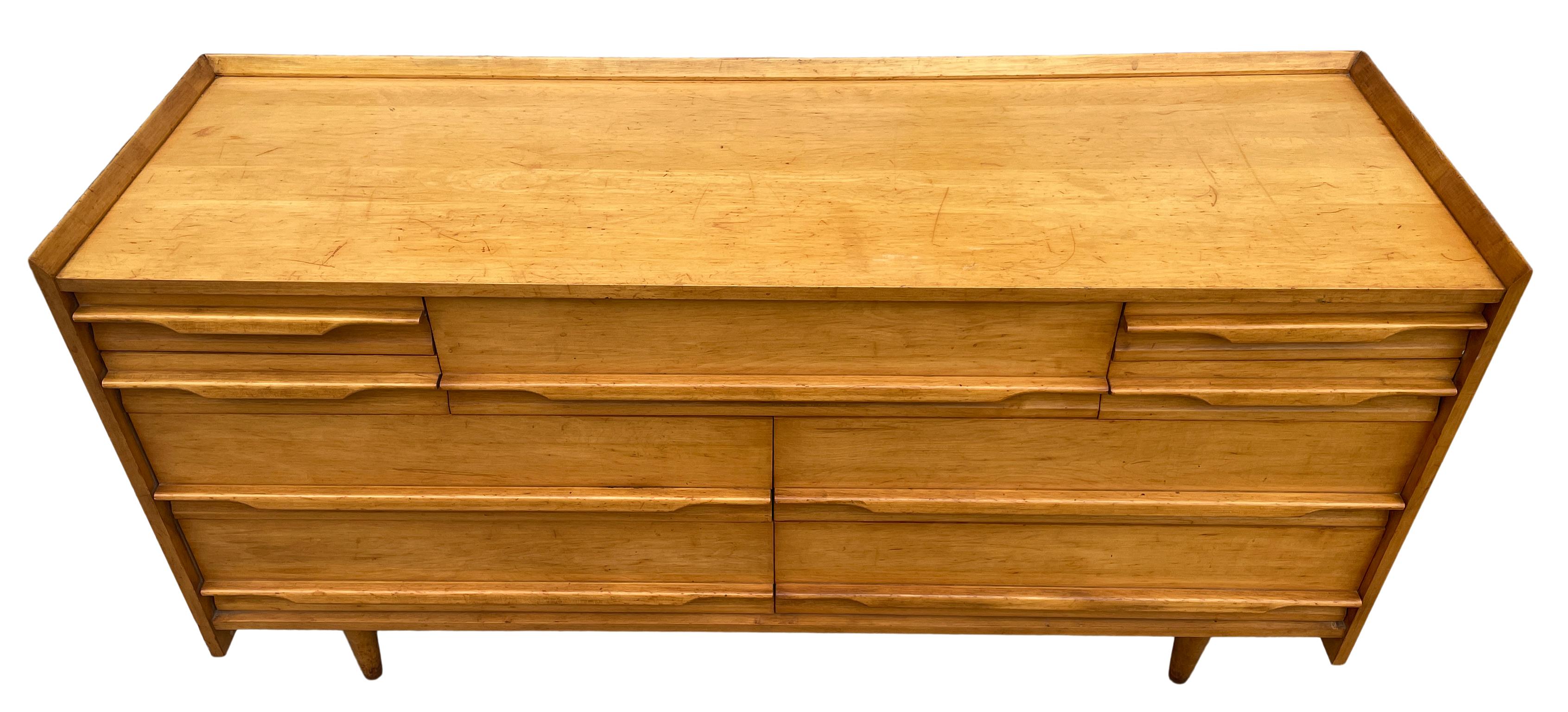 Unique Mid-Century Modern American solid maple tall 9 drawer low long dresser by Crawford. All solid maple construction with carved handles and sits on 4 tapered legs. Vintage original condition. Shows wear on top surface drawers clean inside. Metal