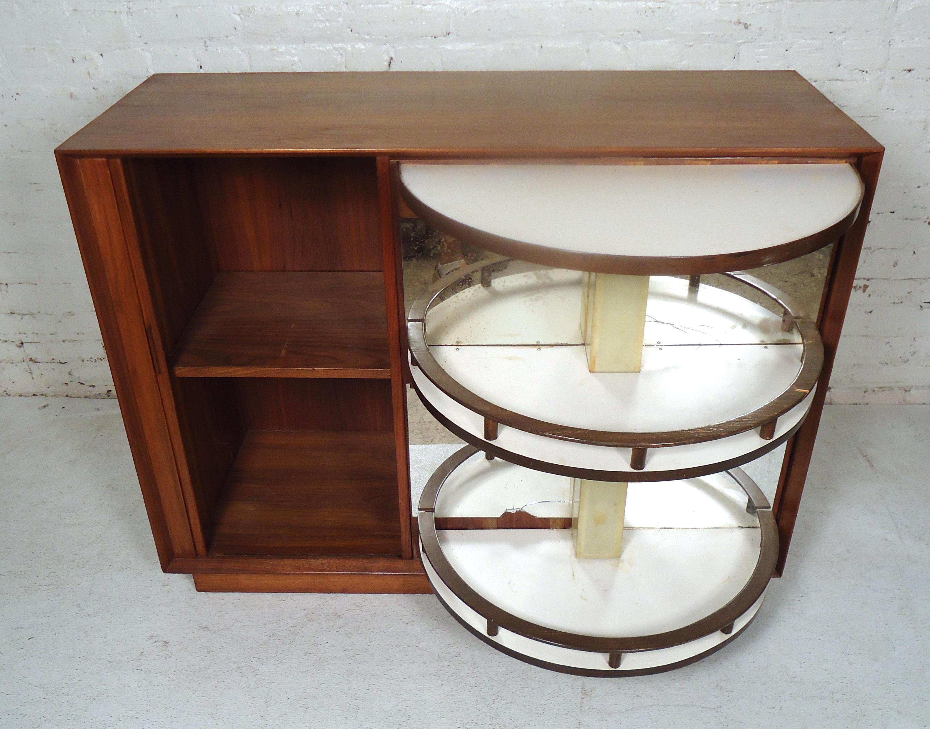 Beautiful vintage modern cabinet featuring a hidden two-tier bar with a mirrored back, and a side tambour door storage cabinet.

(Please confirm item location - NY or NJ - with dealer).