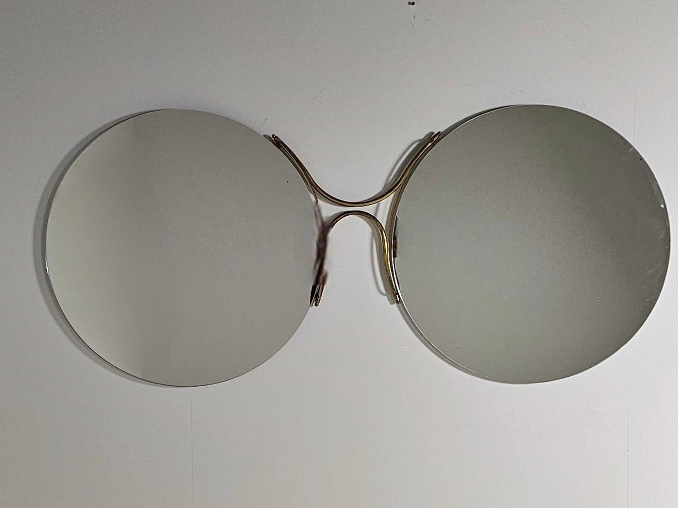 Dieser einzigartige große Spiegel zeichnet sich durch seine elegante Form aus. Der Rahmen ist aus poliertem Messing und weist altersbedingte Oxidation auf.

Ein atemberaubender Spiegel mit Designelementen, die an die Gläser der 1950er Jahre
