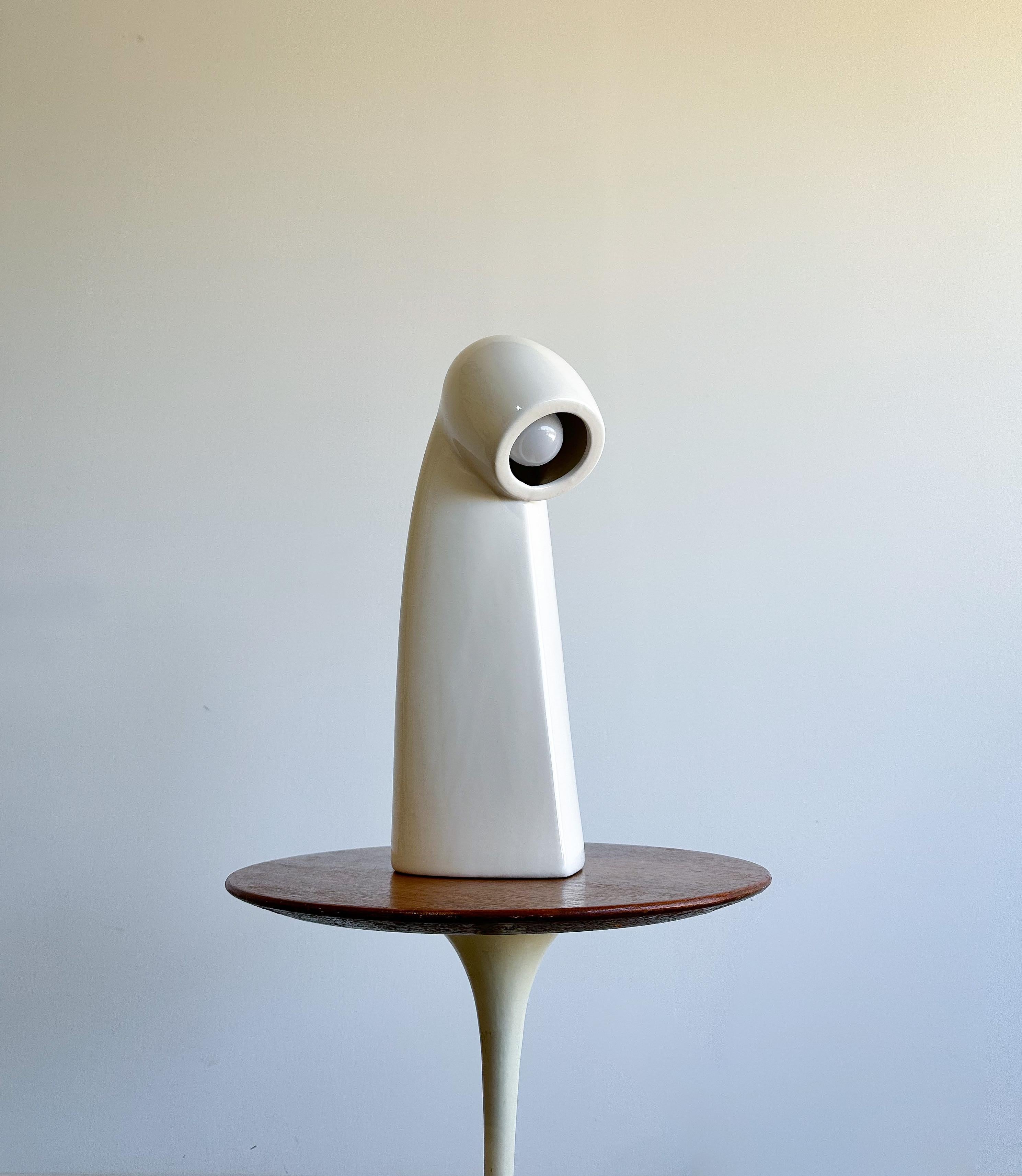 Offered is a fun and unique ceramic table lamp resembling a periscope with its overall design and downward facing illumination.

The designer/maker is unknown, but the design and production were done at a high level.

This would be a great addition