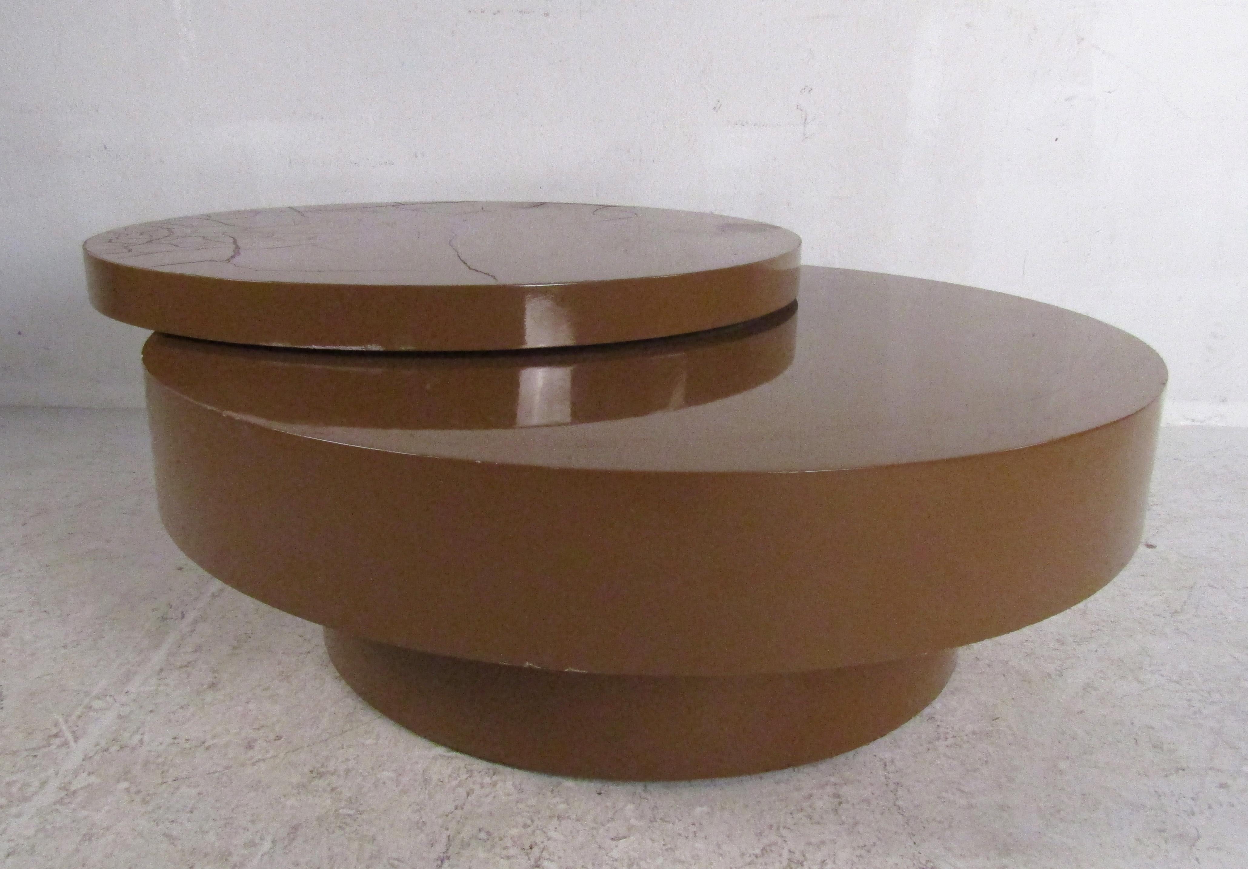This beautiful vintage modern coffee table swivels from 40 inches wide all the way to 49 inches wide. A brown lacquered finish adds to the mid-century appeal. A versatile pedestal-style base makes this unusual cocktail table the perfect addition to