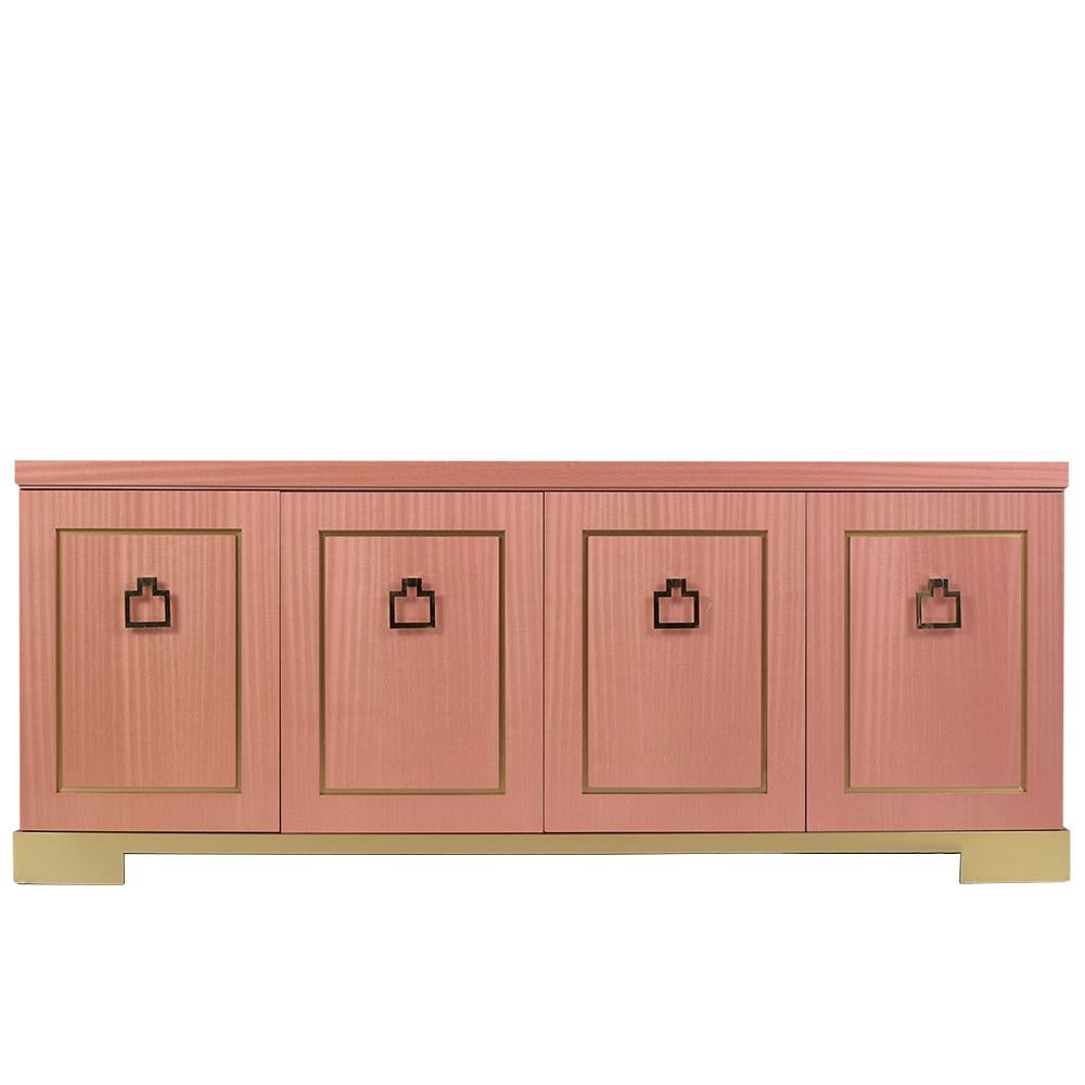 This mid-century modern credenza is in great condition, made out of wood veneered with laminated in a unique pink color and restored by our team of expert professional craftsmen. The piece comes with four doors with large eye-catching brass drop