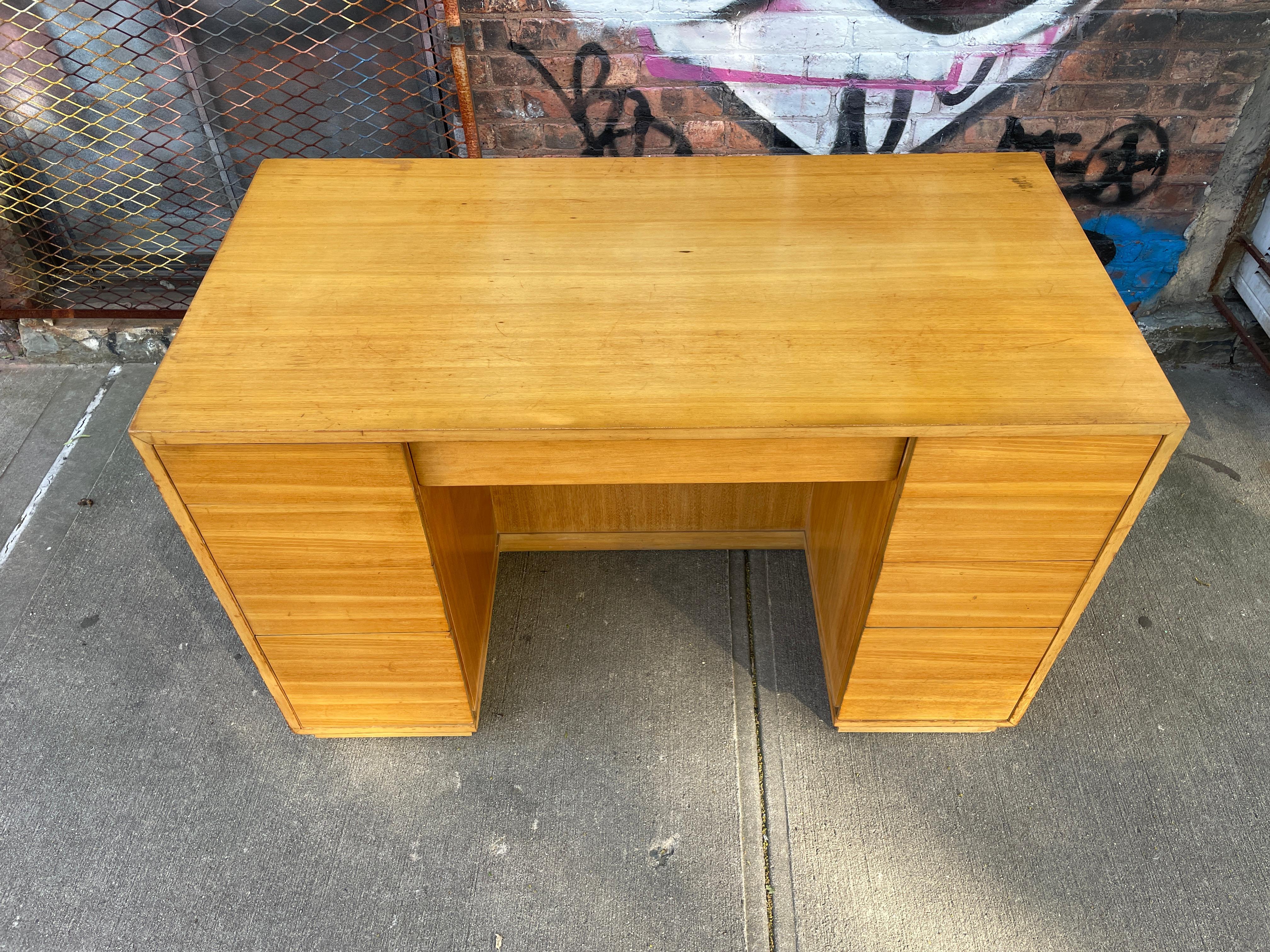 Unique Mid-Century Modern maple 9 drawer desk by Drexel in a blonde maple finish. All solid maple drawers with organizer trays and lowered drawers have deep paper file slots. Very unique great design and compact size. Front side has 2 open book